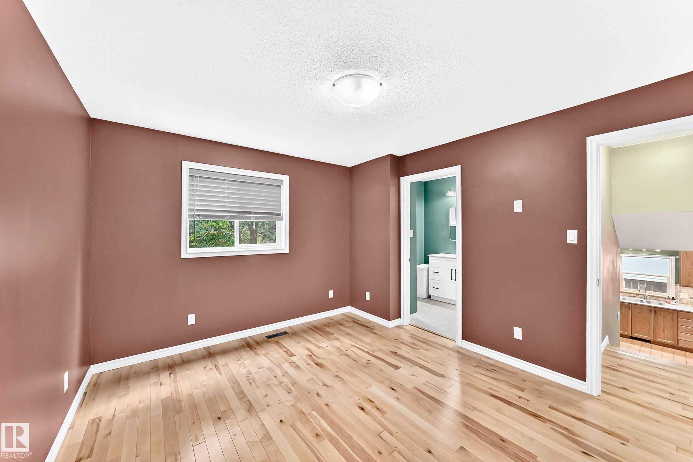 Room featuring wood-finish flooring, a window with horizontal blinds, and a flush mount ceiling light - 1763 48A Street, Edmonton, AB