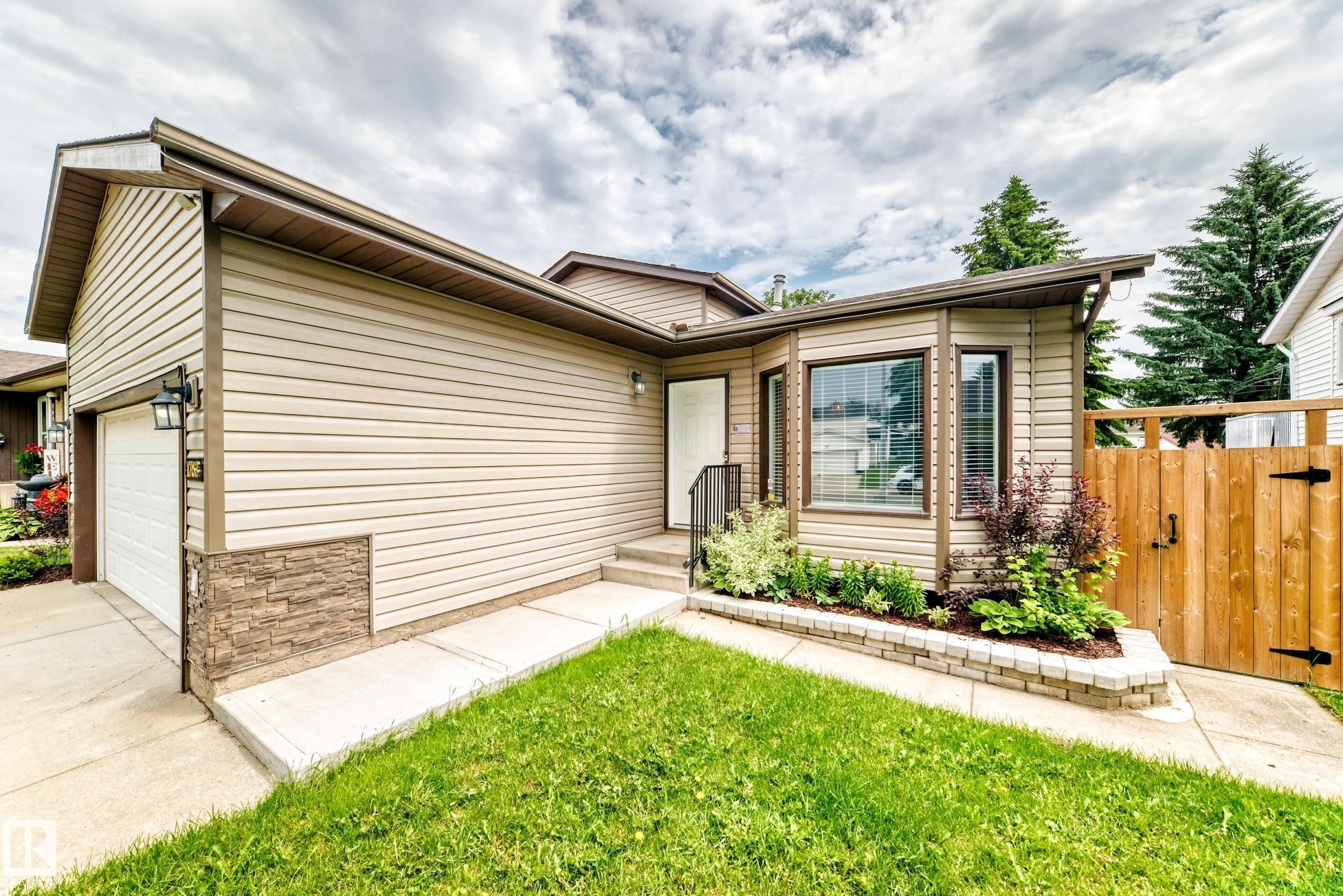 Exterior featuring beige horizontal siding with stone veneer accents - 1763 48A Street, Edmonton, AB