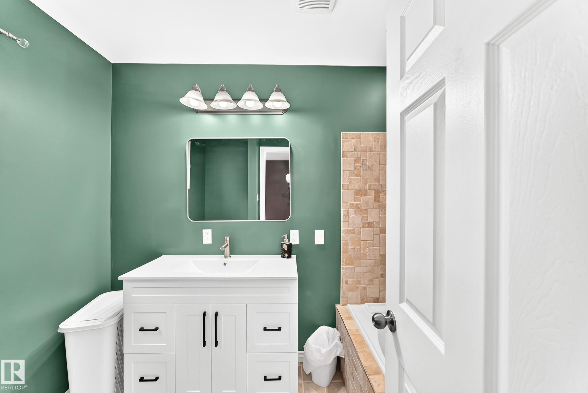 White vanity with black hardware, rectangular undermount sink, and brushed nickel faucet - 1763 48A Street, Edmonton, AB