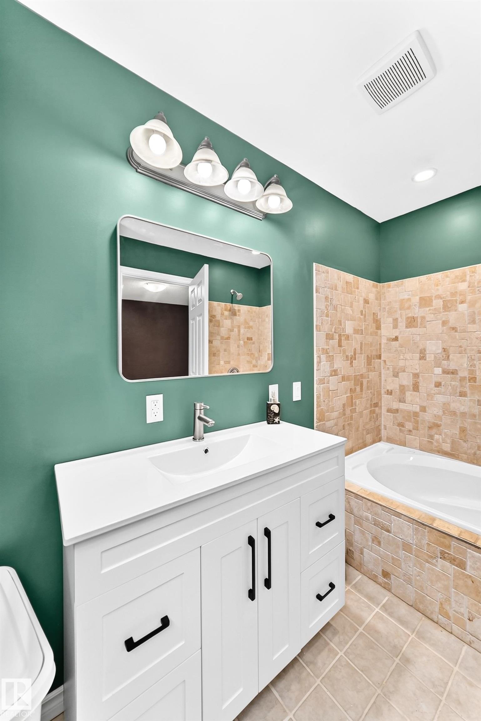 Bathroom featuring a white vanity with an integrated sink, brushed nickel faucet, and matte black hardware - 1763 48A Street, Edmonton, AB