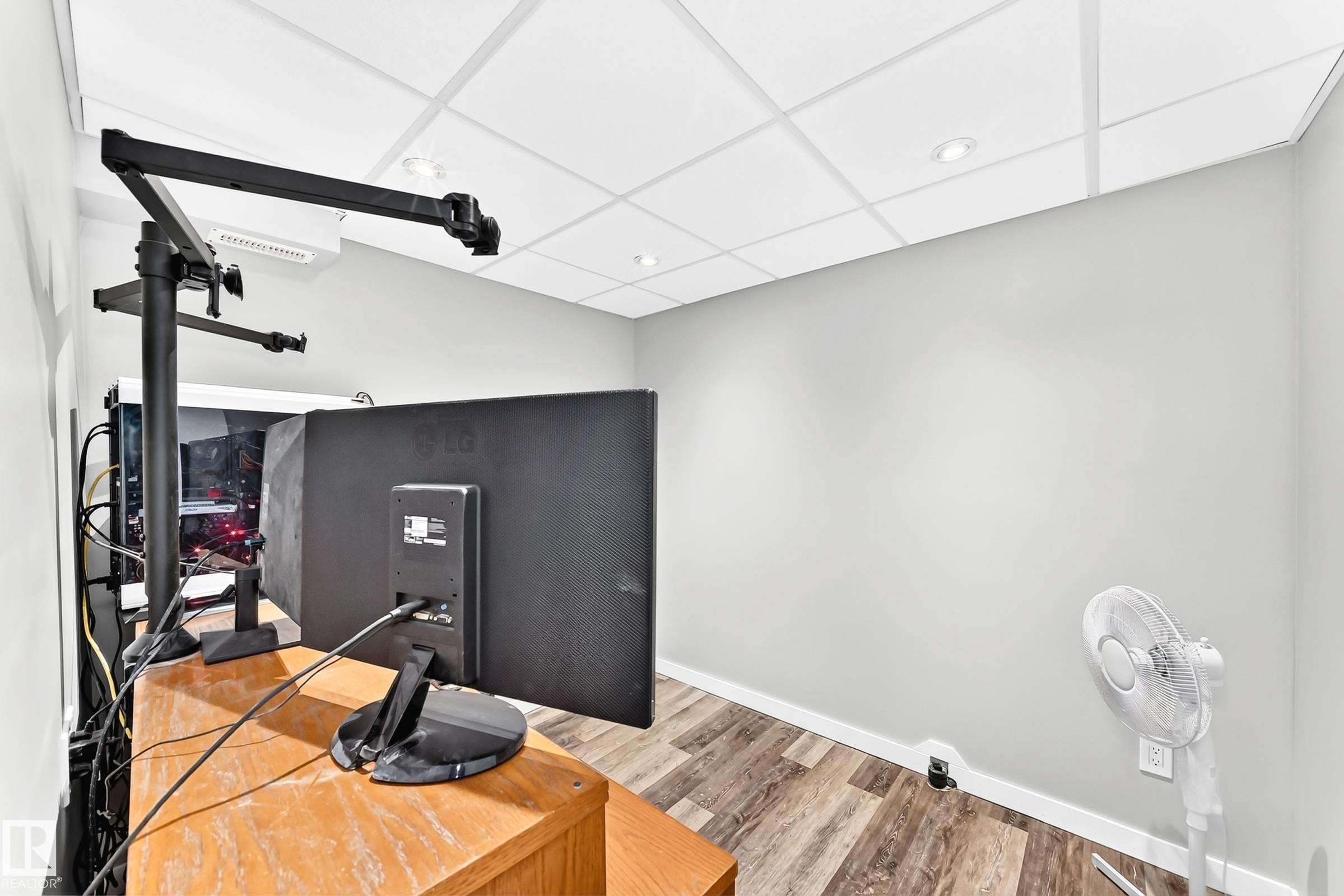 Room featuring wood-finish flooring, light gray wall paint, and a grid drop ceiling with recessed lighting - 1763 48A Street, Edmonton, AB