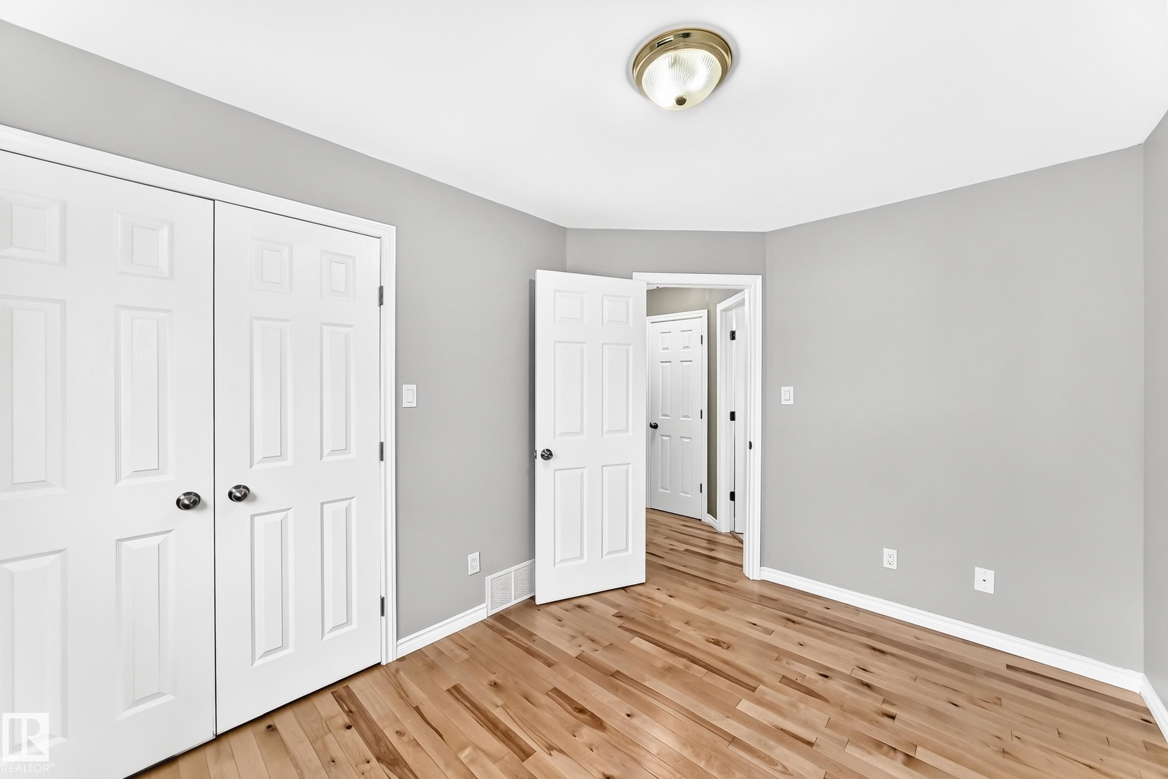 Interior room featuring wood-finish flooring, light gray wall paint, and white trim - 1763 48A Street, Edmonton, AB