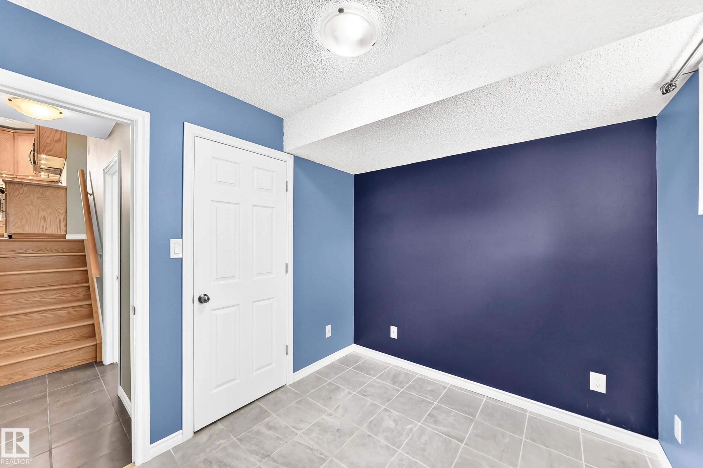Room featuring a full wall in a deep blue tone, complemented by lighter blue walls and a white ceiling - 1763 48A Street, Edmonton, AB