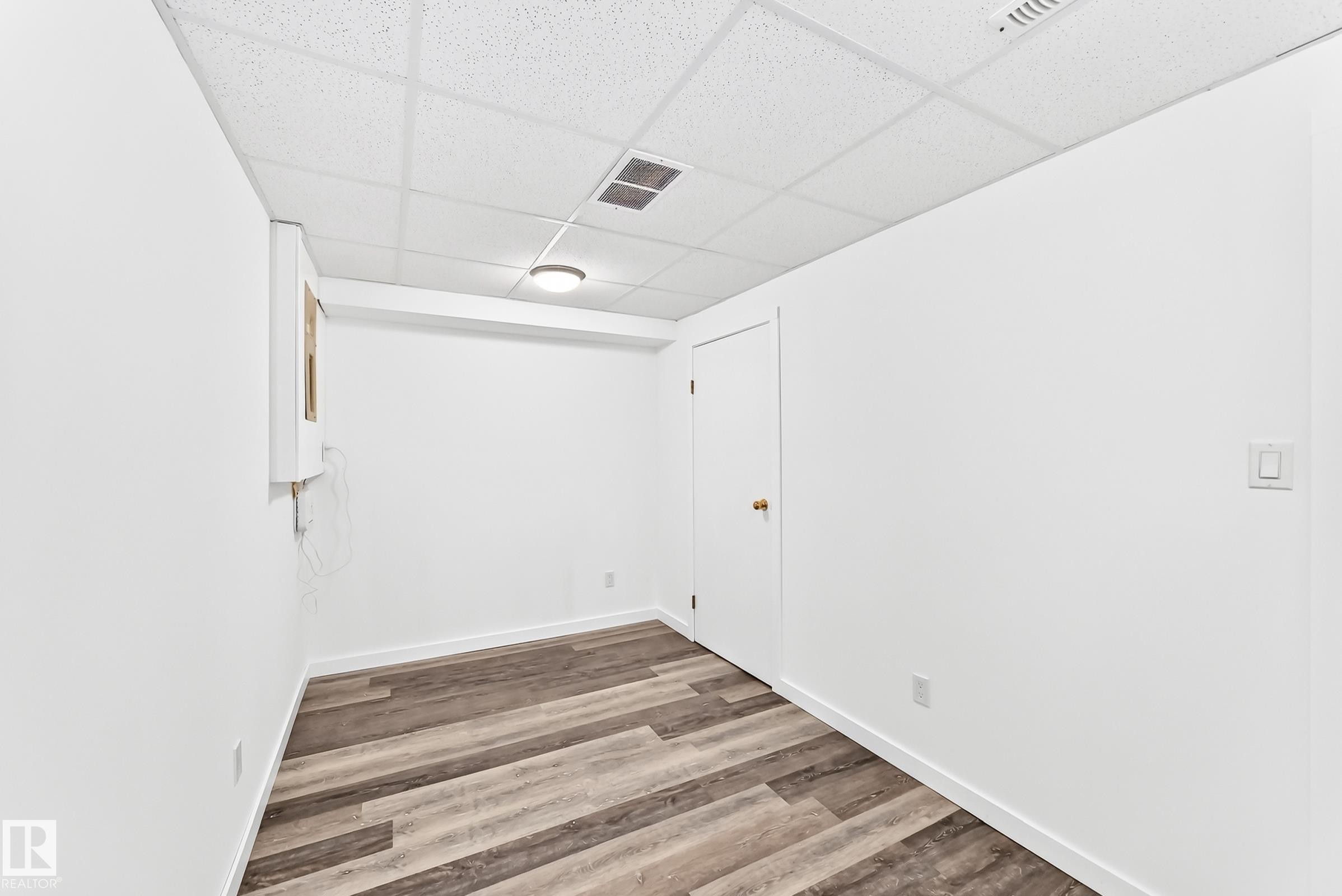 Room with wood-finish flooring, white walls, and a drop ceiling - 1763 48A Street, Edmonton, AB