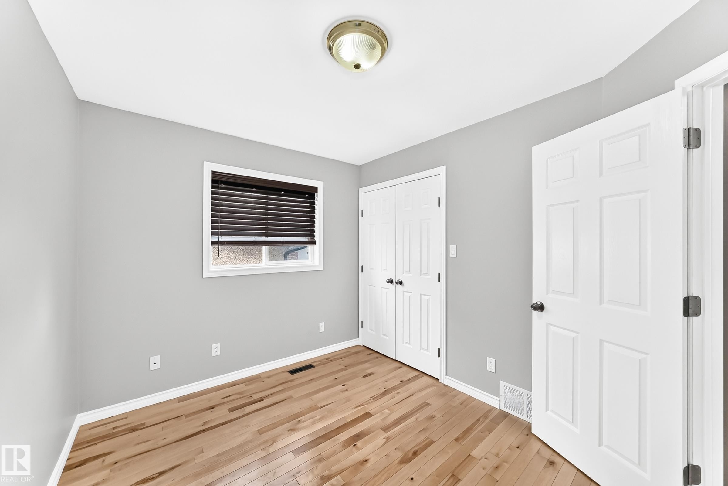 Room with light wood-finish flooring, light gray walls, and white trim - 1763 48A Street, Edmonton, AB