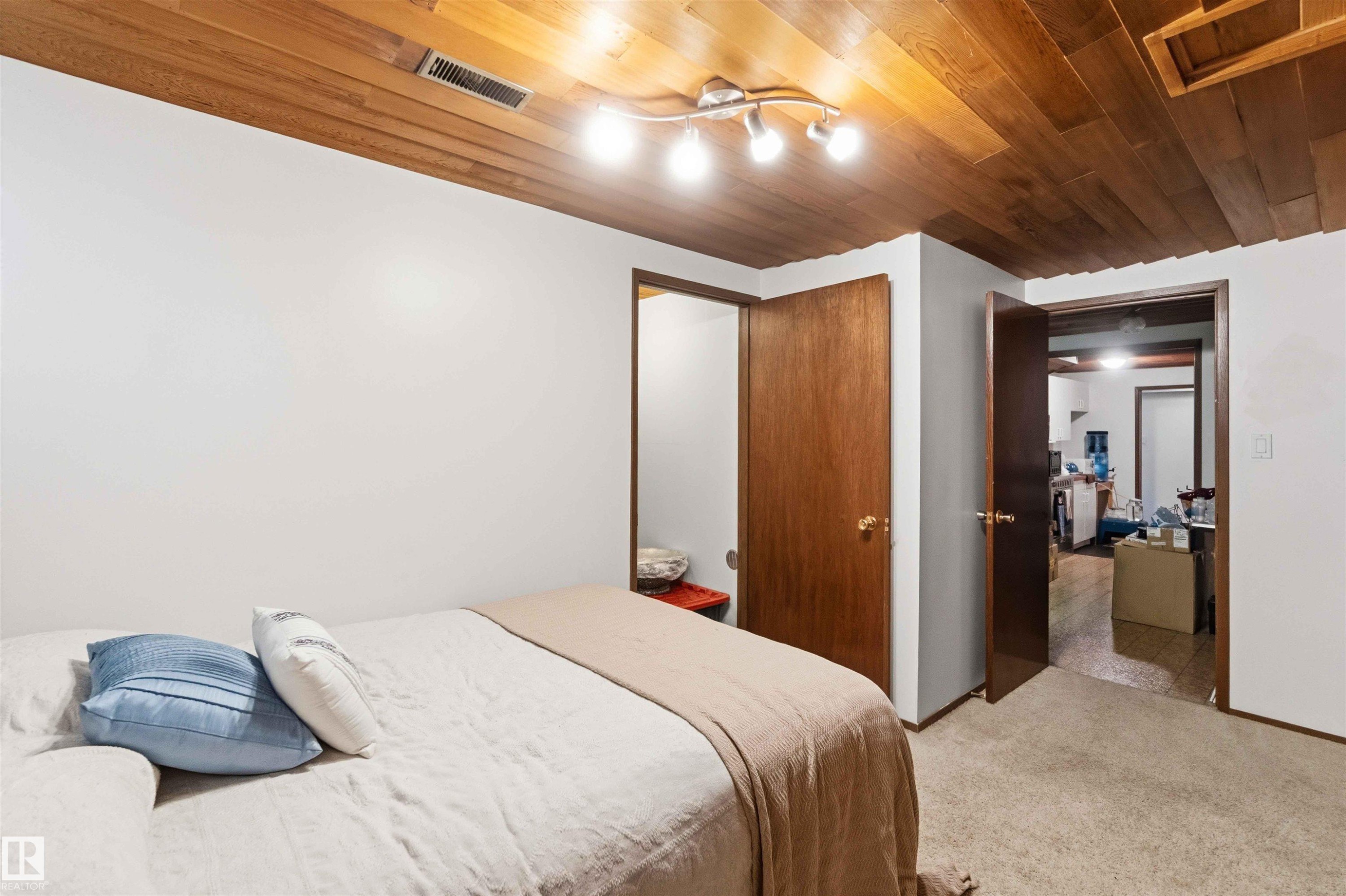 Wood-paneled ceiling with track lighting, neutral wall finishes, and wood-finish doors - 13121 122 Street, Edmonton, AB