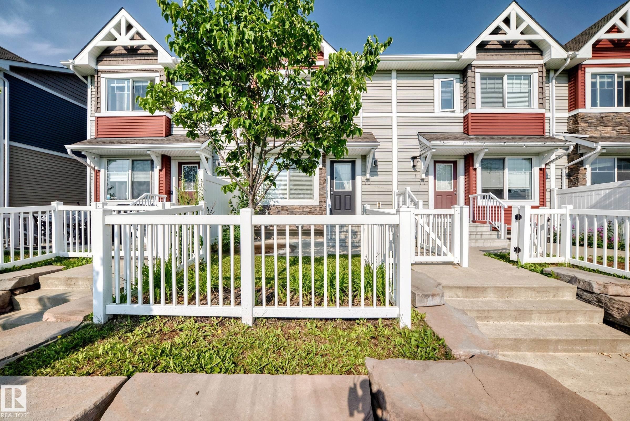Townhome exterior featuring gabled rooflines and mixed material siding - 415 Clareview Rd Nw Nw, Edmonton, AB - Outdoor With Facade