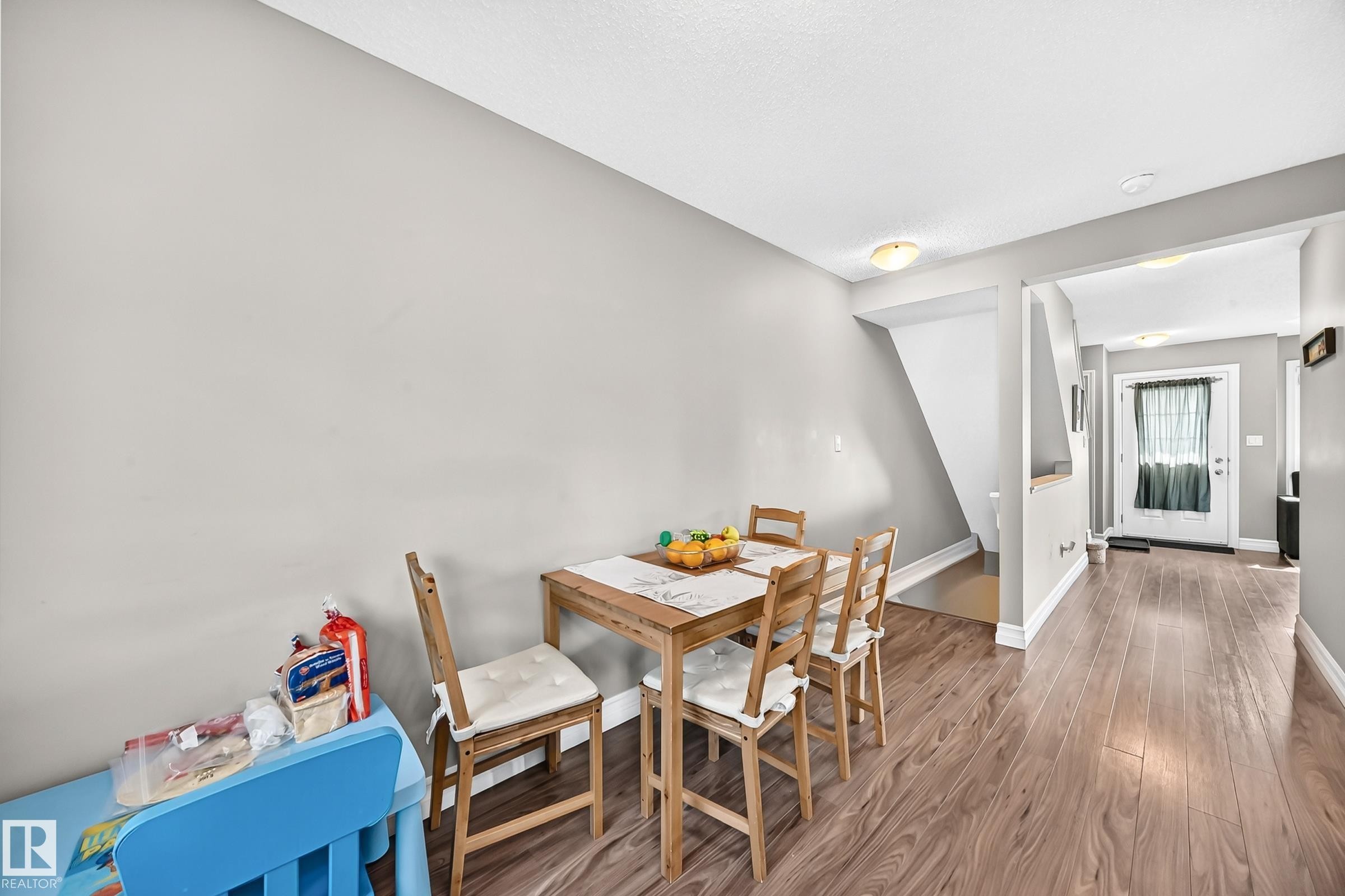 Open-concept living space featuring wood-finish flooring, light grey wall paint, and white trim - 415 Clareview Rd Nw Nw, Edmonton, AB - Indoor Photo Showing Dining Room