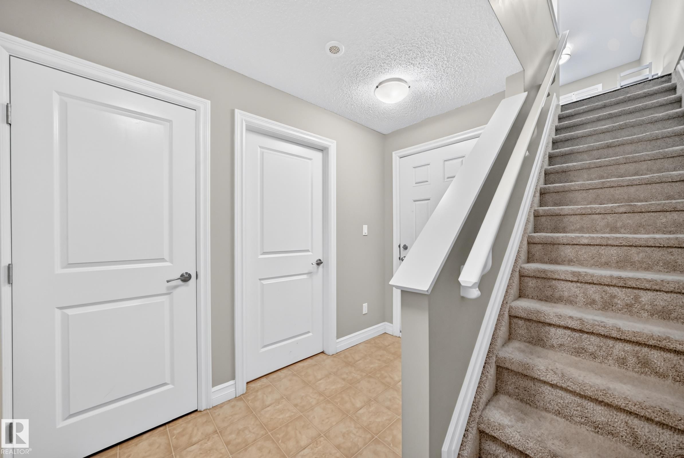 Carpeted staircase with white balusters, leading to an upper level - 415 Clareview Rd Nw Nw, Edmonton, AB - Indoor Photo Showing Other Room