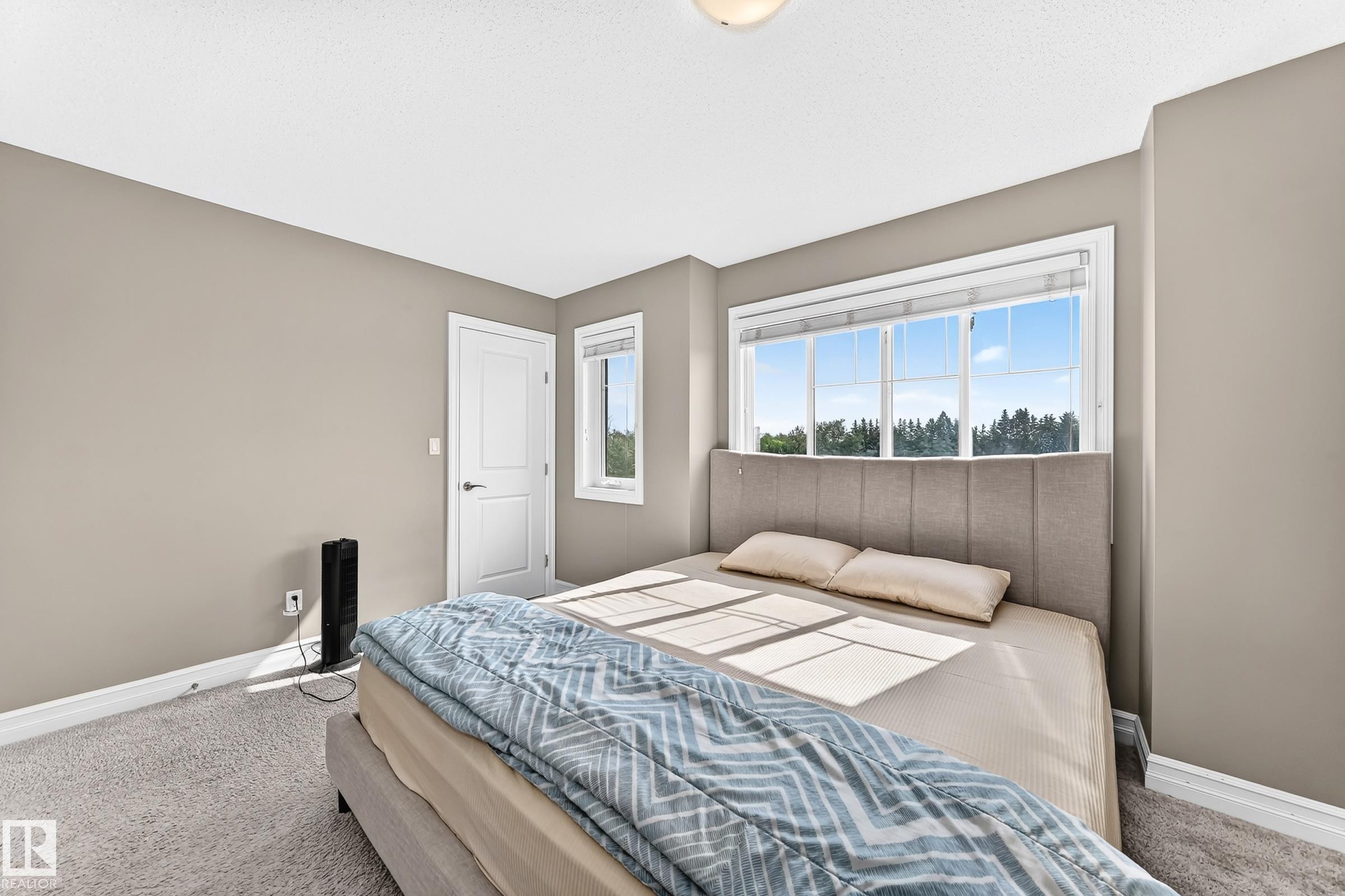 Bright room featuring a large window, neutral carpeting, and light taupe walls - 415 Clareview Rd Nw Nw, Edmonton, AB - Indoor Photo Showing Bedroom