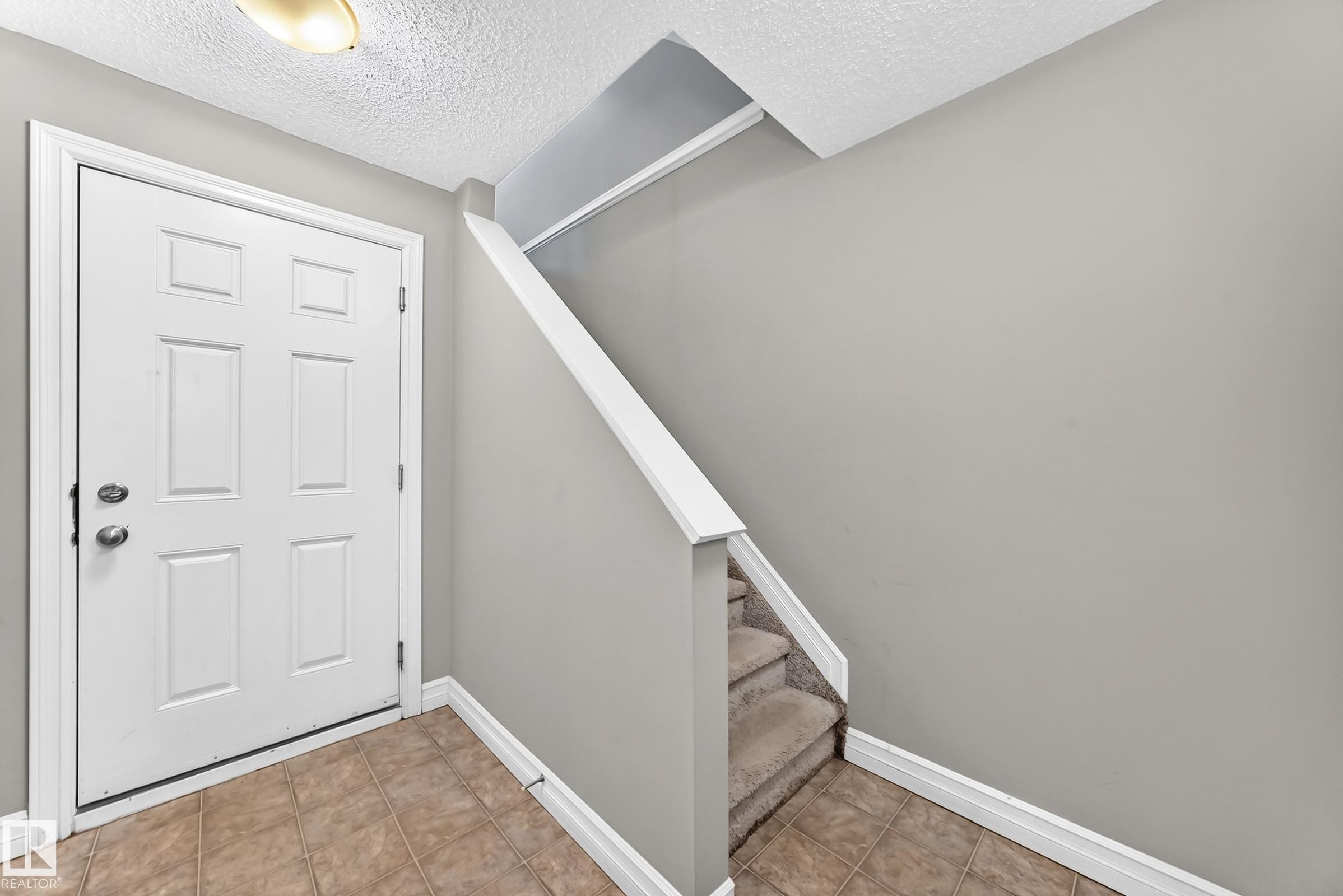 Entryway featuring a white paneled door, neutral wall paint, and ceramic tile flooring - 415 Clareview Rd Nw Nw, Edmonton, AB - Indoor Photo Showing Other Room