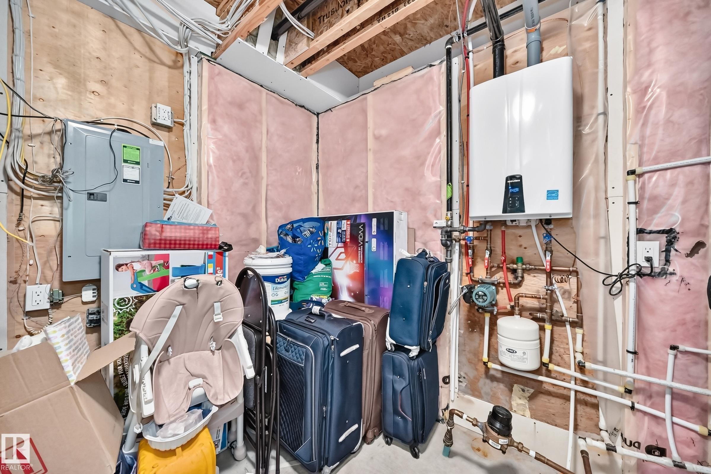 Utility space featuring a wall-mounted water heater, exposed electrical panel, and PEX piping - 415 Clareview Rd Nw Nw, Edmonton, AB - Indoor