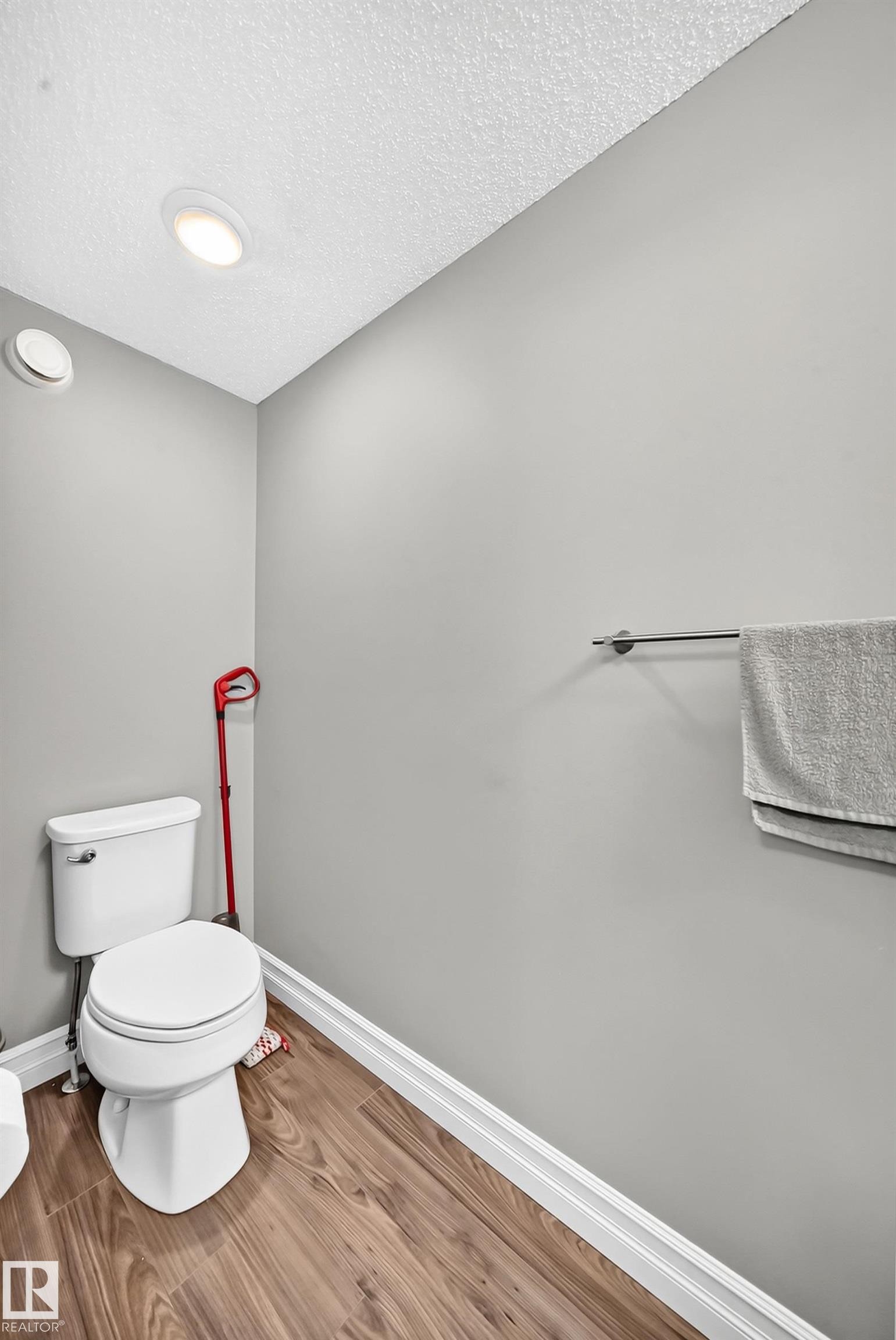 Powder room featuring light gray walls, wood-finish flooring, recessed lighting, and a white toilet - 415 Clareview Rd Nw Nw, Edmonton, AB - Indoor Photo Showing Bathroom