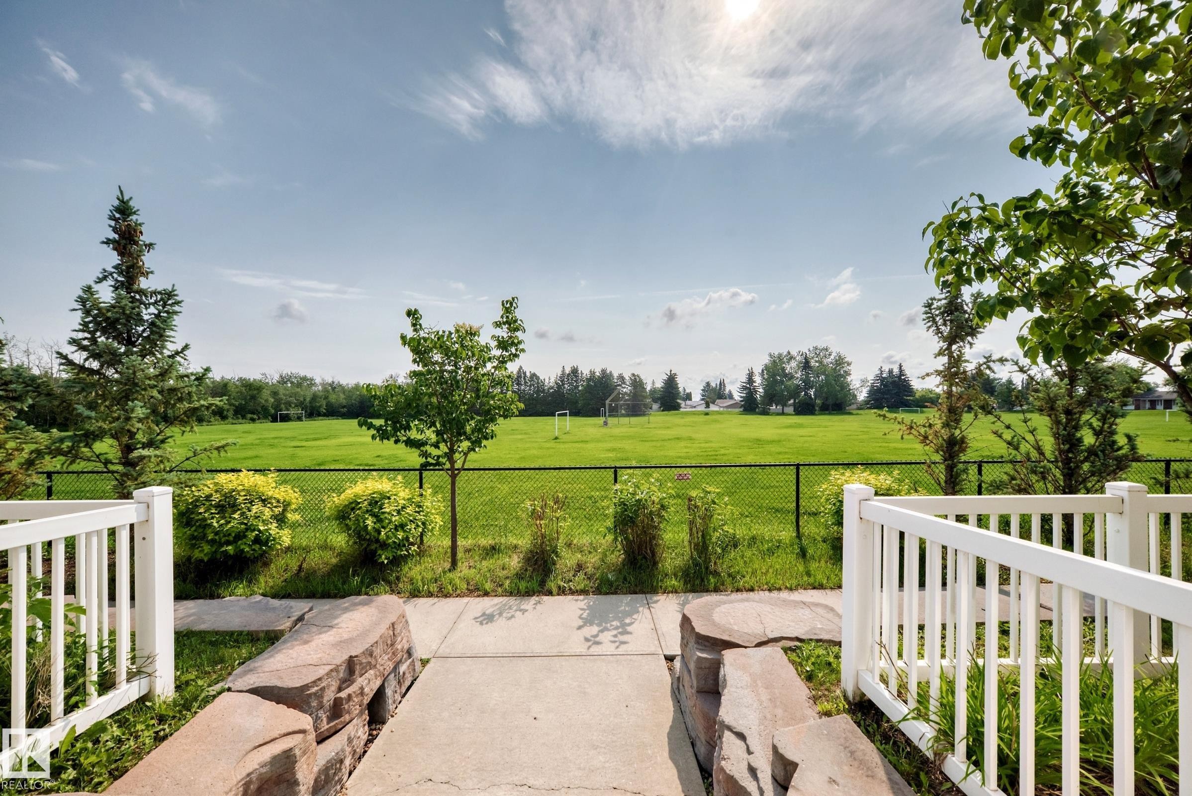 Landscaped pathway leading to a fenced green space - 415 Clareview Rd Nw Nw, Edmonton, AB - Outdoor