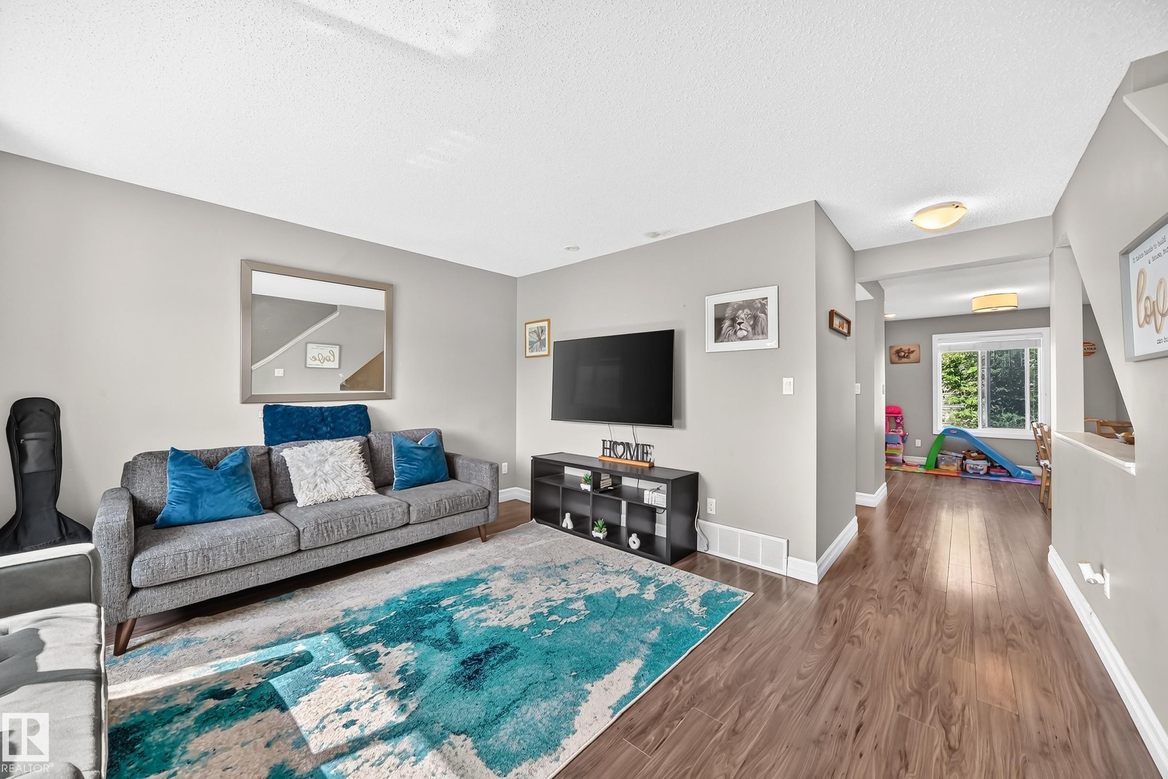 Living area featuring wood-finish flooring, light gray walls, and recessed lighting - 415 Clareview Rd Nw Nw, Edmonton, AB - Indoor Photo Showing Living Room