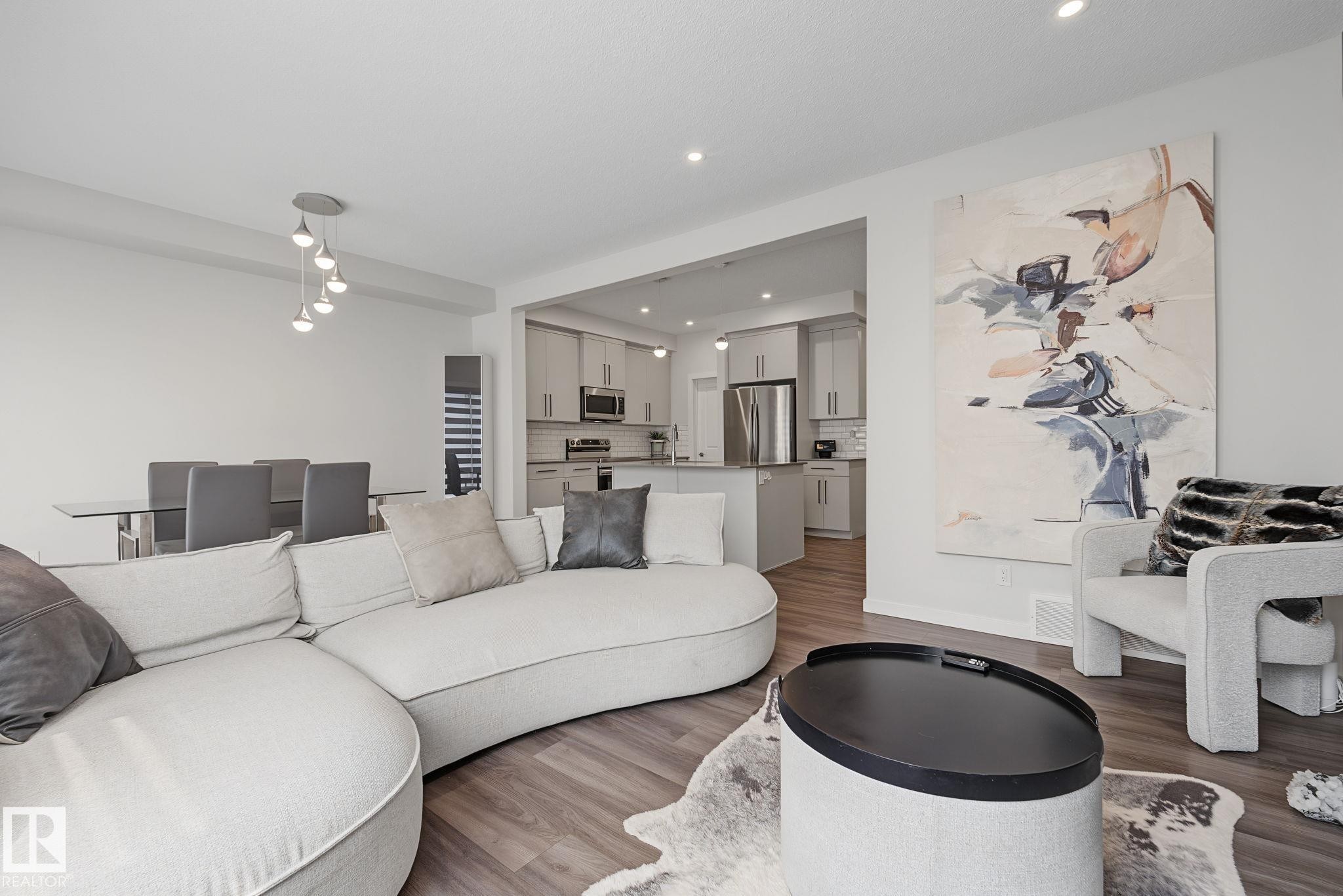 Open-concept living space featuring wood-finish flooring and recessed lighting - 432 Roberts Crescent, Leduc, AB