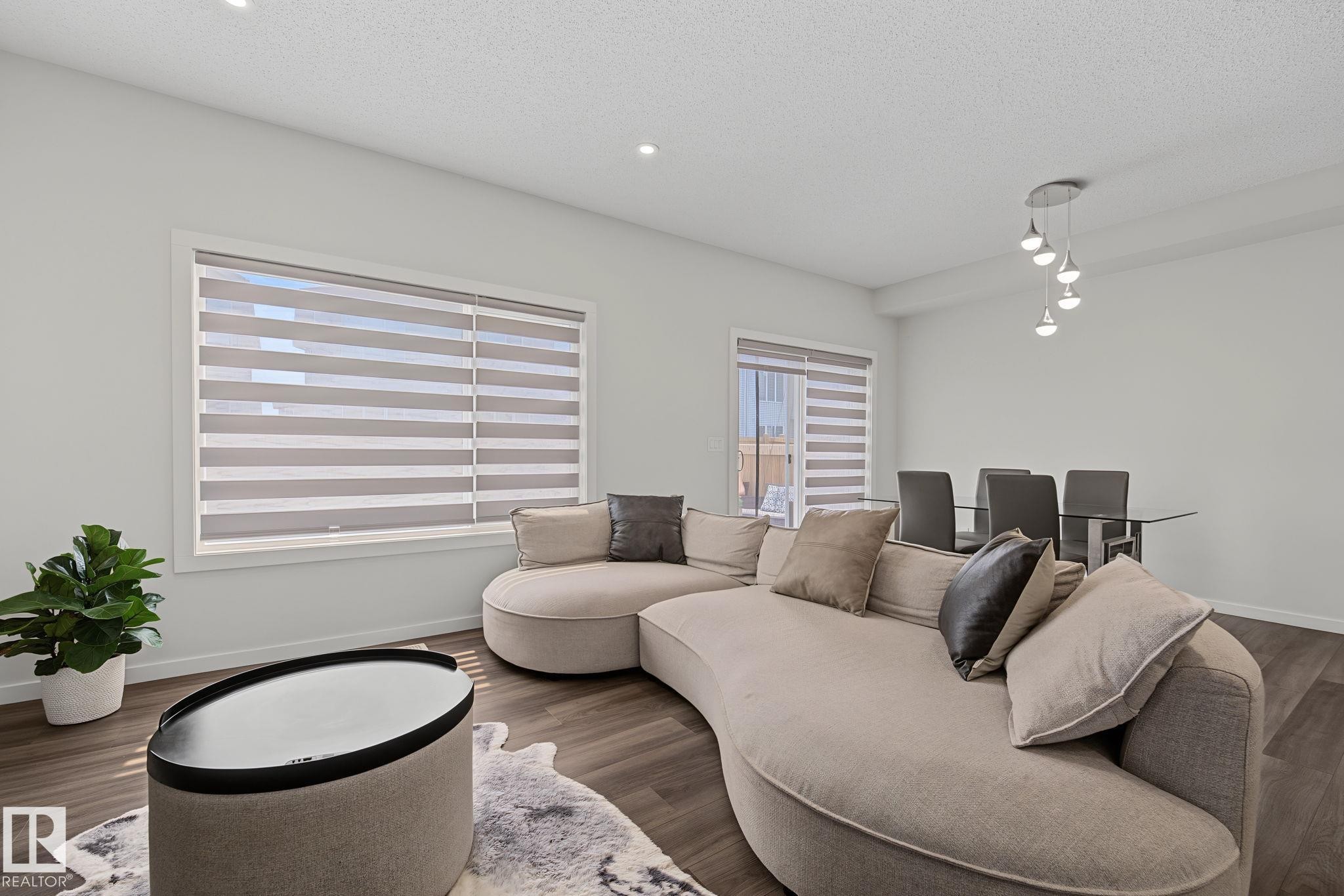 Open-concept living area with dark wood-finish flooring - 432 Roberts Crescent, Leduc, AB