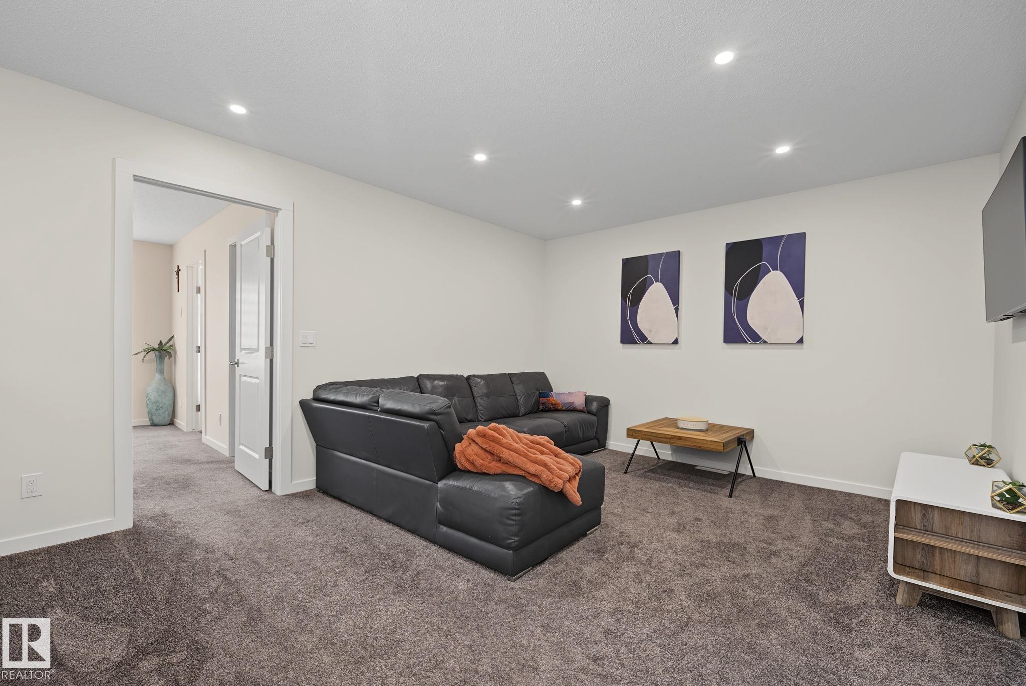 Spacious room featuring plush gray carpeting, recessed ceiling lighting, and crisp white walls - 432 Roberts Crescent, Leduc, AB