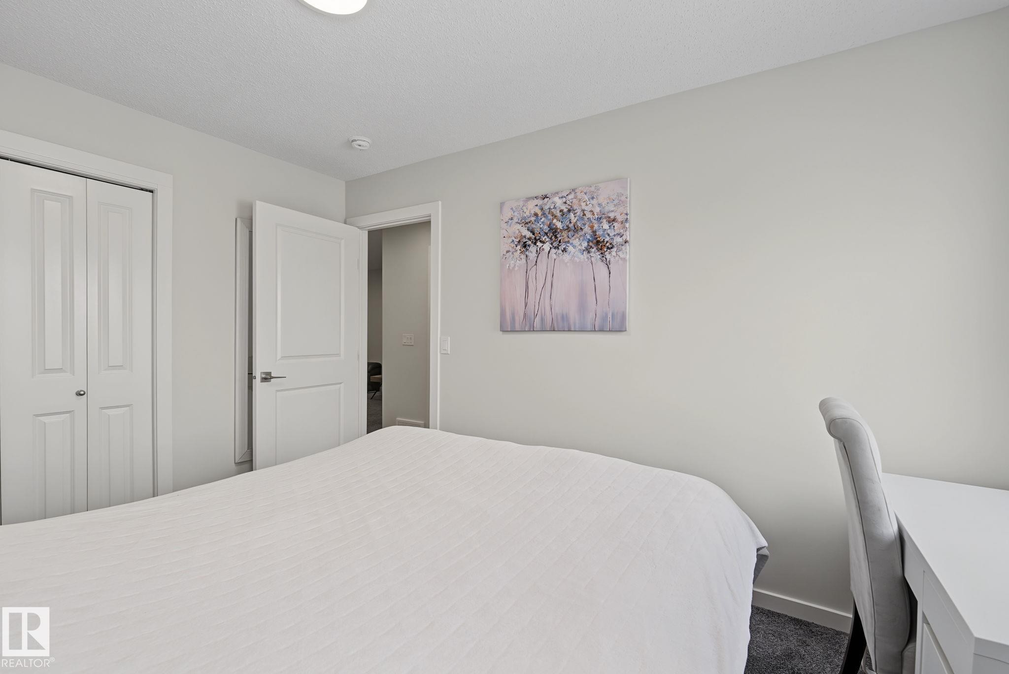 Neutral wall paint and dark carpet flooring establish a clean aesthetic - 432 Roberts Crescent, Leduc, AB