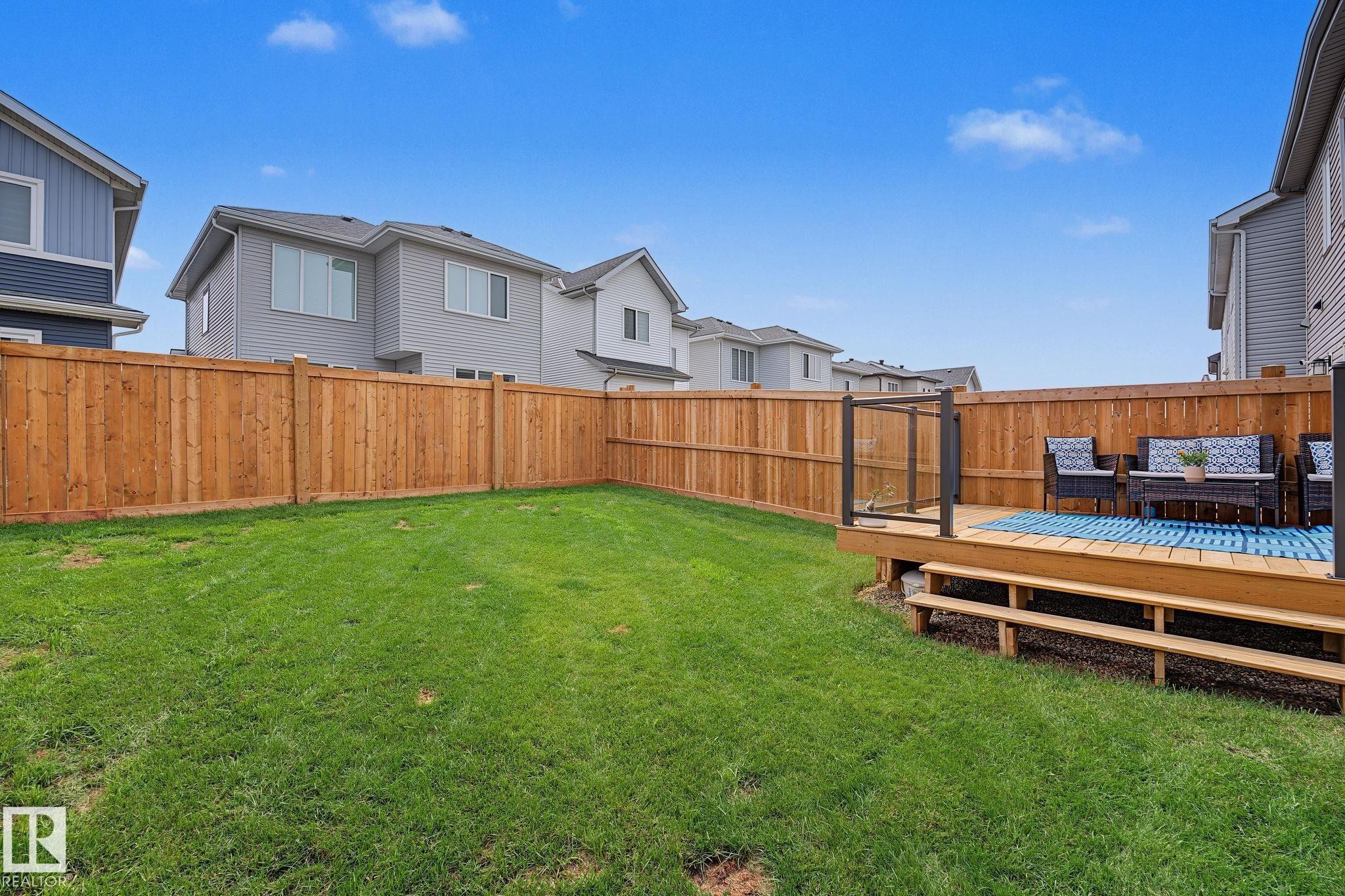 Expansive backyard featuring a natural wood fence and a green lawn - 432 Roberts Crescent, Leduc, AB