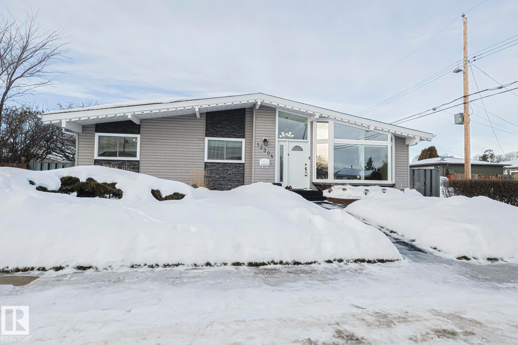 Single-story residence featuring light gray siding with dark stone accents - 13304 70 Street, Edmonton, AB