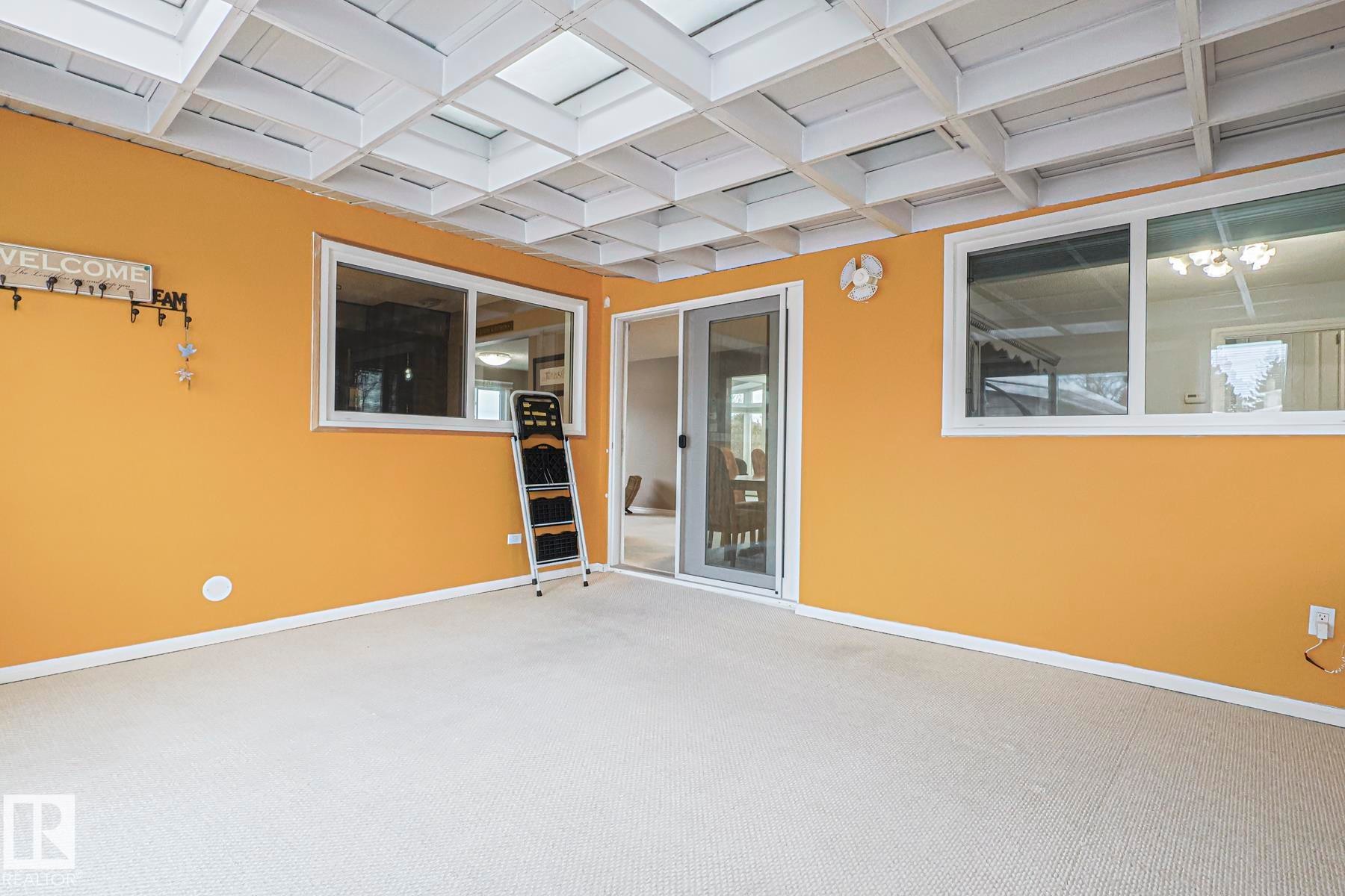 Carpeted interior space featuring a grid-patterned ceiling with multiple skylights - 13304 70 Street, Edmonton, AB