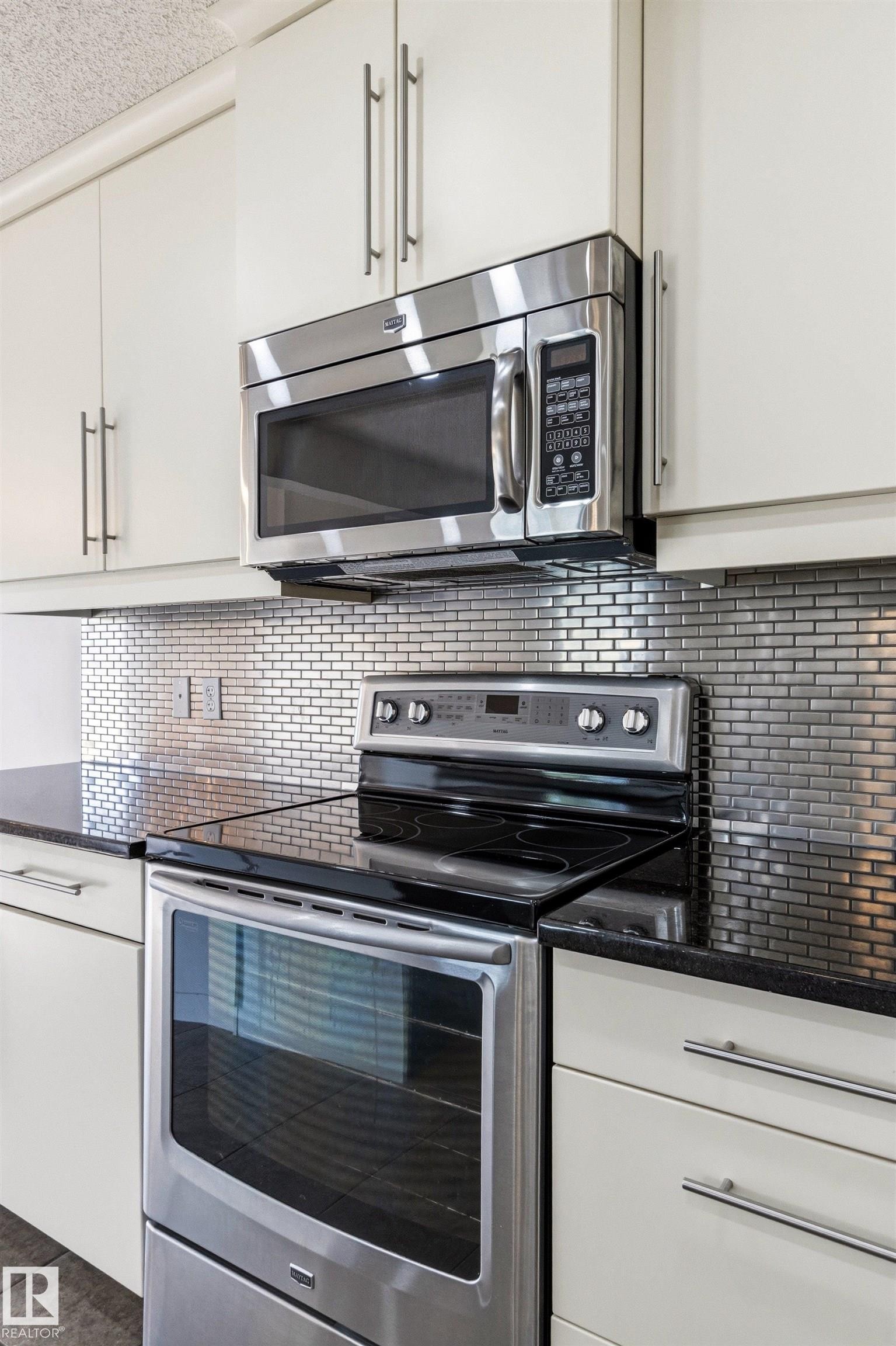 Kitchen featuring stainless steel appliances, including an electric range with a smooth cooktop and an over-the-range microwave - 3214 22A Avenue Nw, Edmonton, AB - Indoor Photo Showing Kitchen With Stainless Steel Kitchen With Upgraded Kitchen