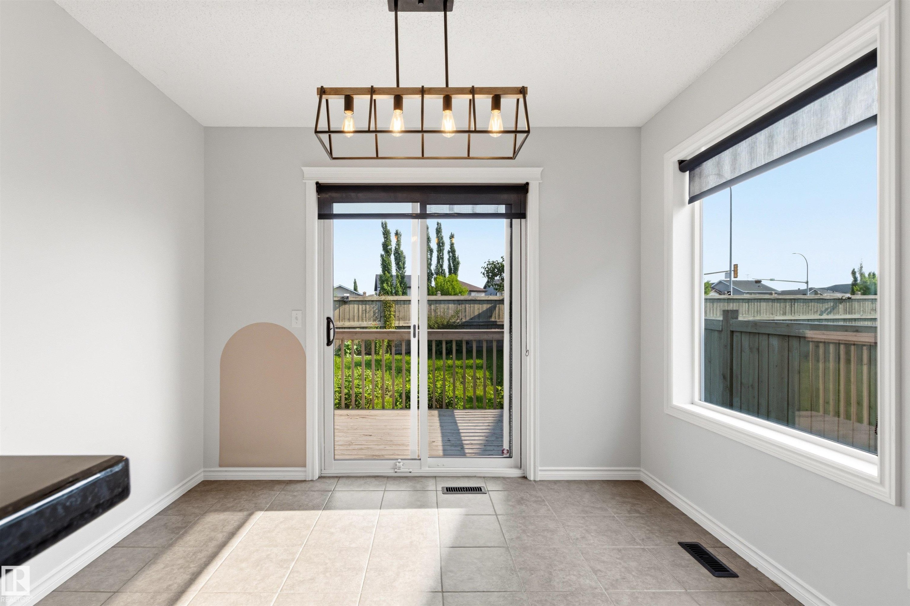 Bright dining space featuring a sliding glass door to the deck and a large window - 3214 22A Avenue Nw, Edmonton, AB - Indoor Photo Showing Other Room