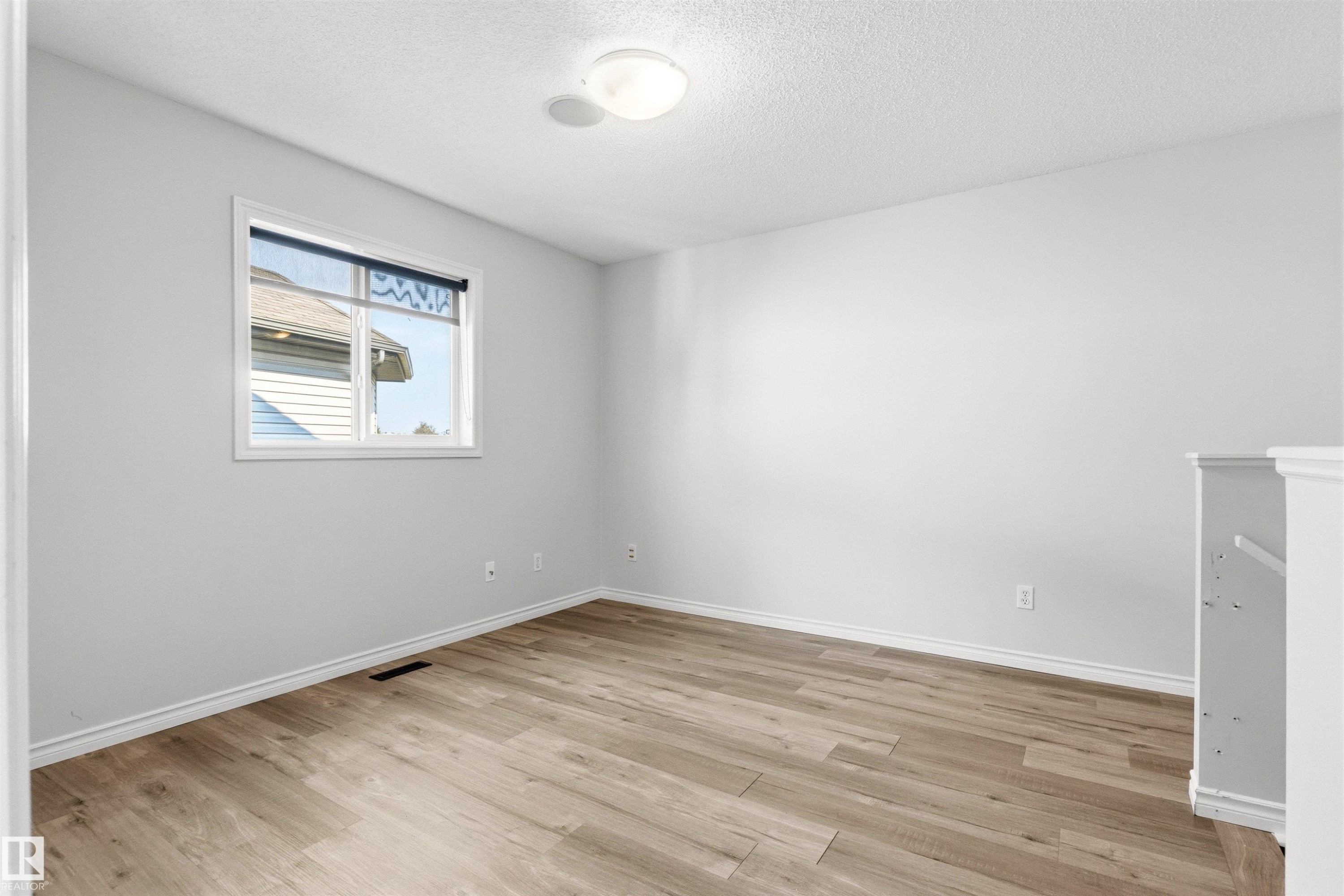 Room featuring wood-finish flooring, light grey walls, and white trim - 3214 22A Avenue Nw, Edmonton, AB - Indoor Photo Showing Other Room