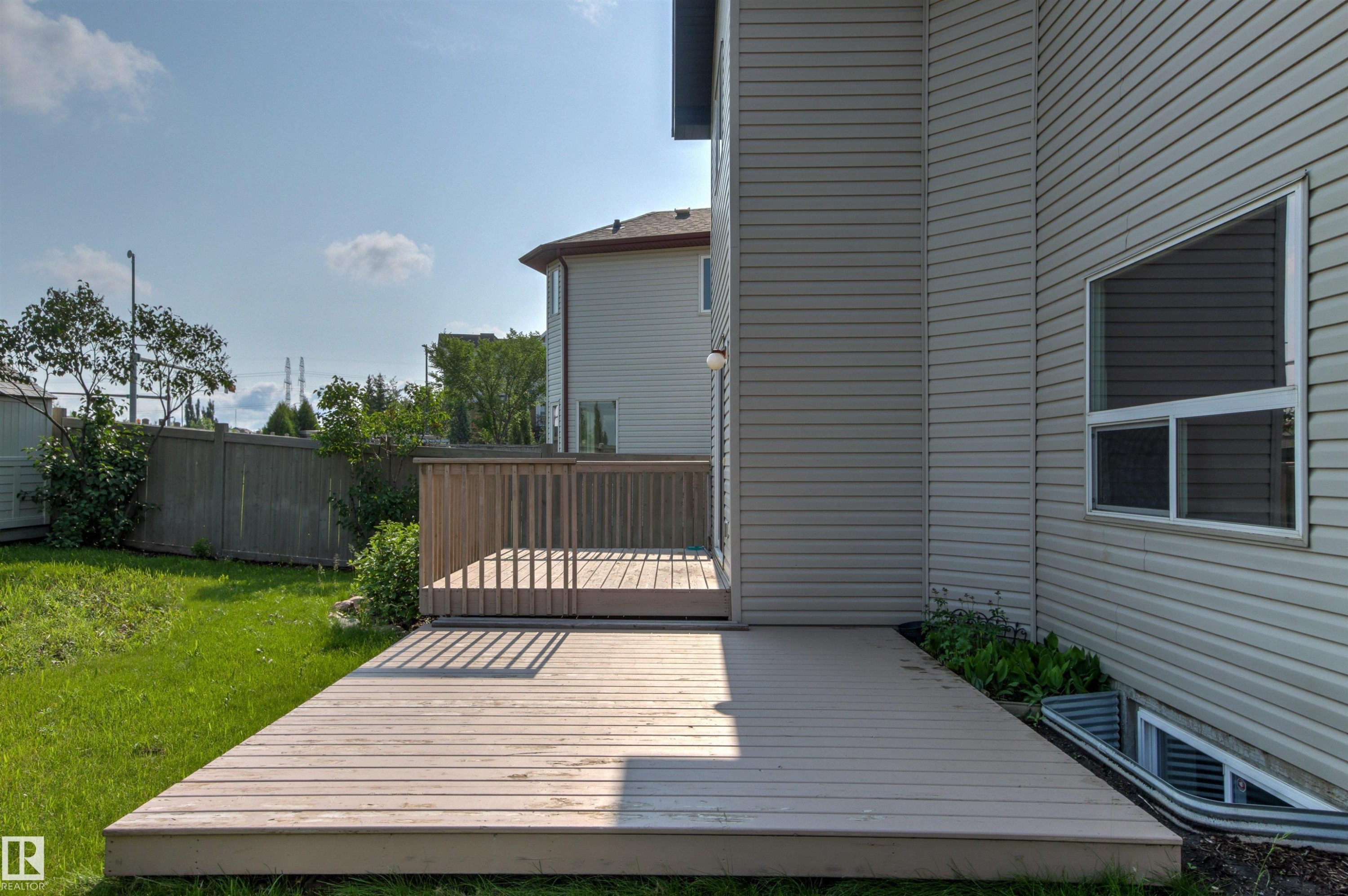 Expansive wood deck with railing and direct access to the interior - 3214 22A Avenue Nw, Edmonton, AB - Outdoor With Exterior