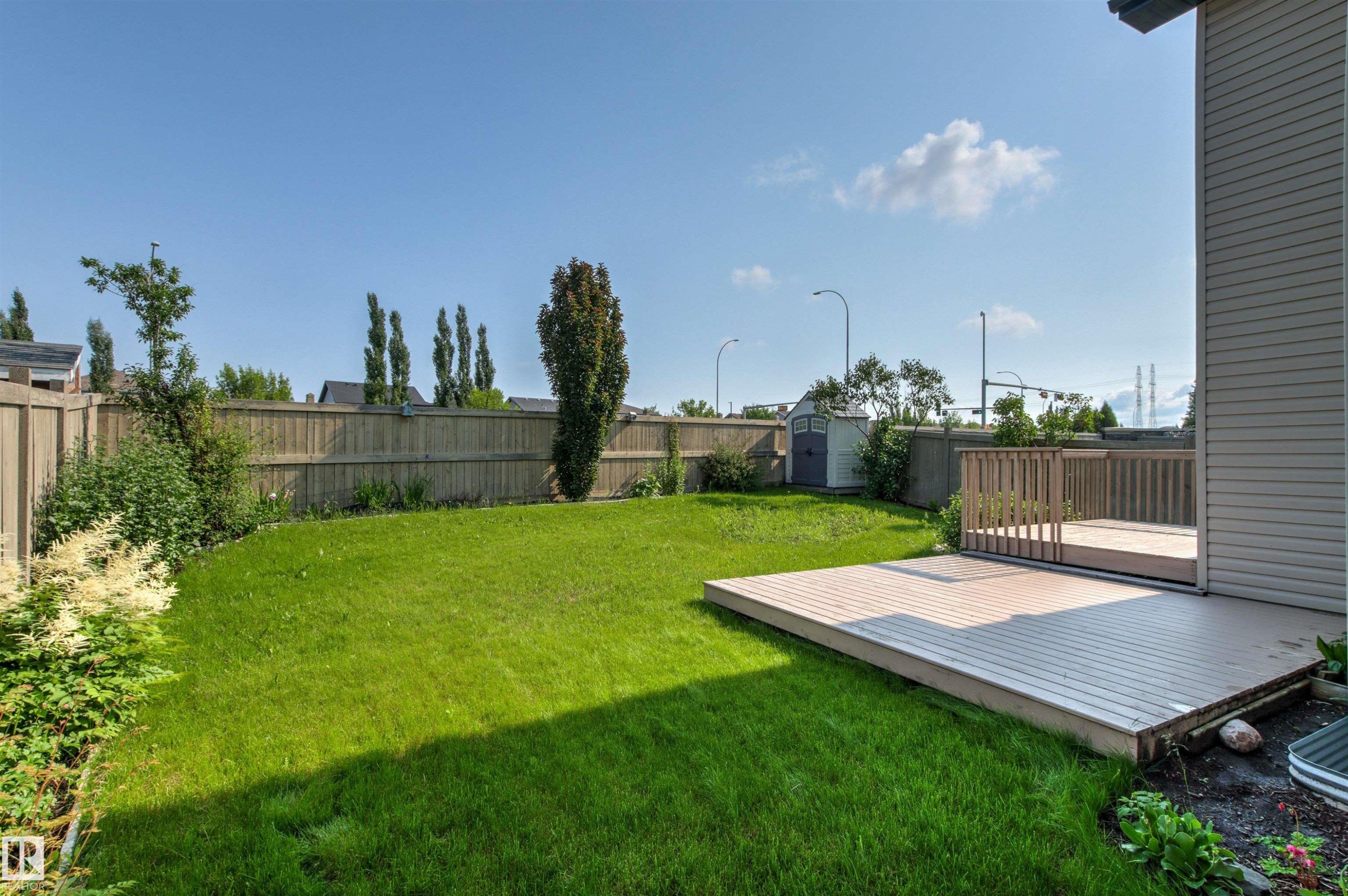 Expansive green lawn with a wood fence perimeter - 3214 22A Avenue Nw, Edmonton, AB - Outdoor With Backyard