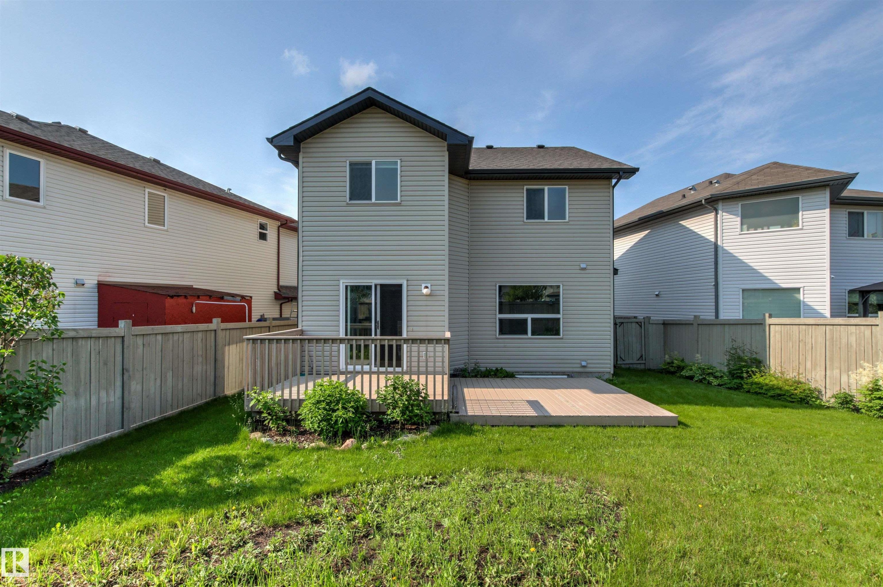 Rear exterior of a two-story residence with light-colored horizontal siding and a dark shingle roof - 3214 22A Avenue Nw, Edmonton, AB - Outdoor