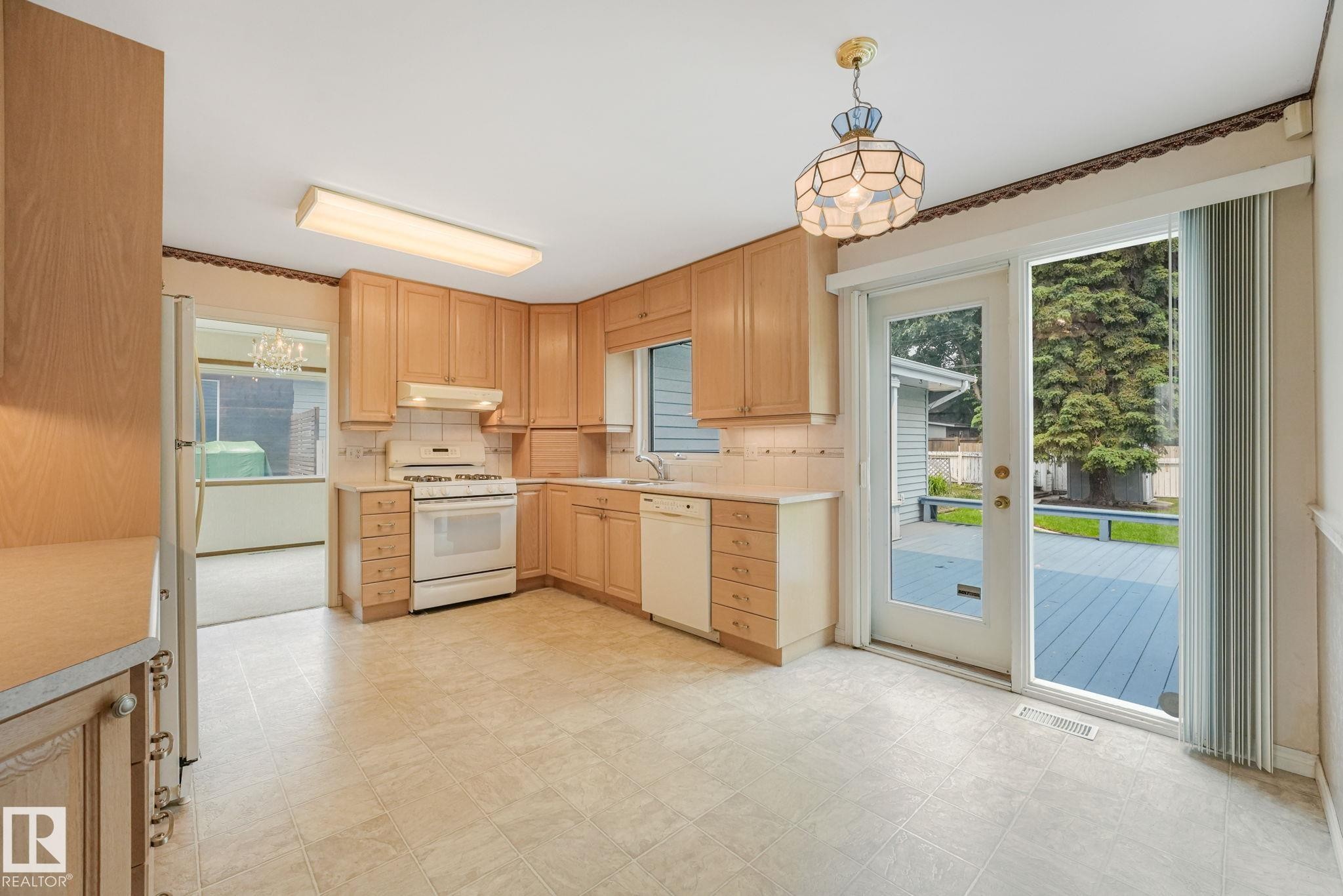 Kitchen featuring light wood cabinetry, tiled backsplash, and light-toned flooring - 13320 79 Avenue Nw, Edmonton, AB - Indoor Photo Showing Kitchen