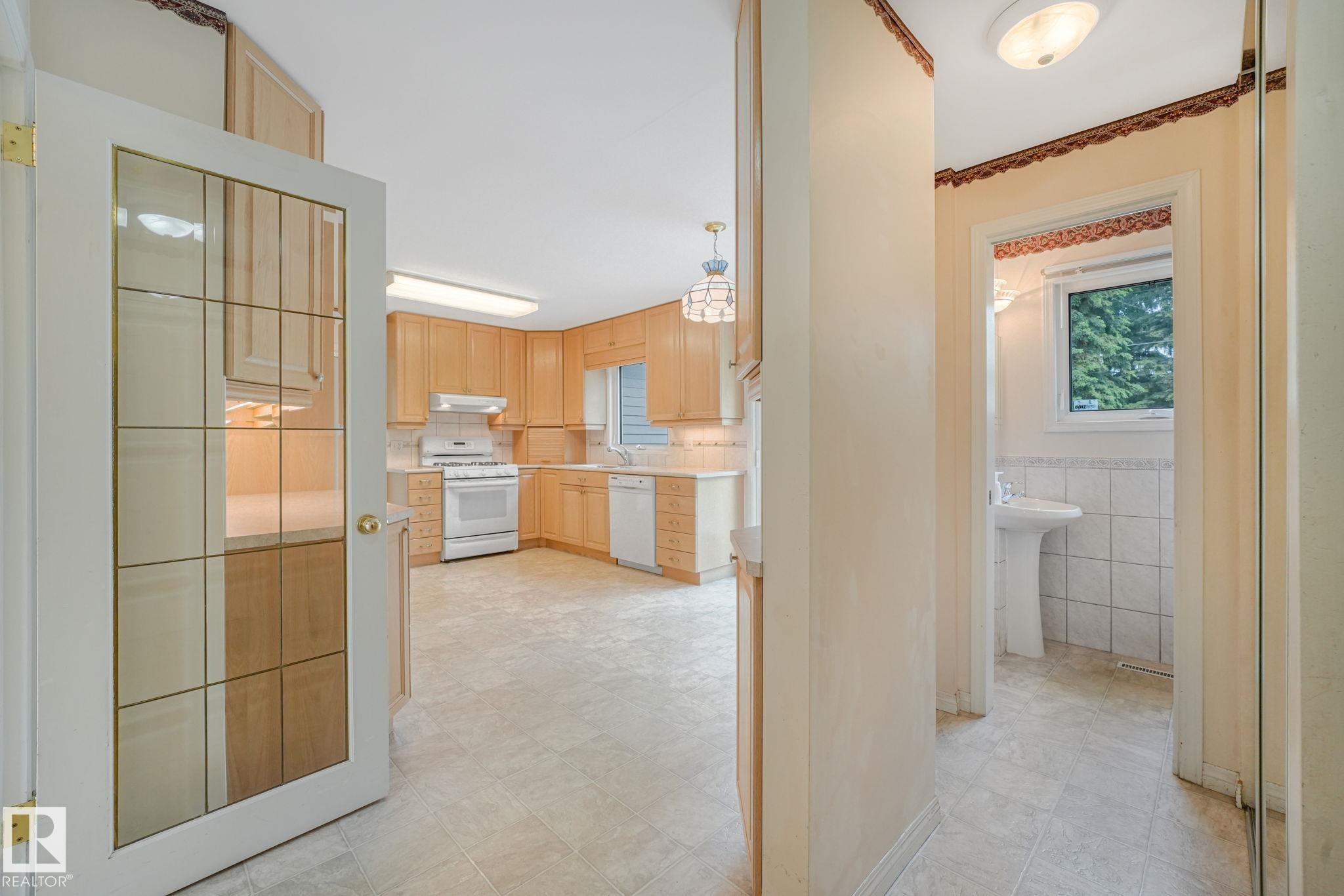 Kitchen featuring light wood cabinetry, white appliances, and a tiled backsplash - 13320 79 Avenue Nw, Edmonton, AB - Indoor Photo Showing Kitchen