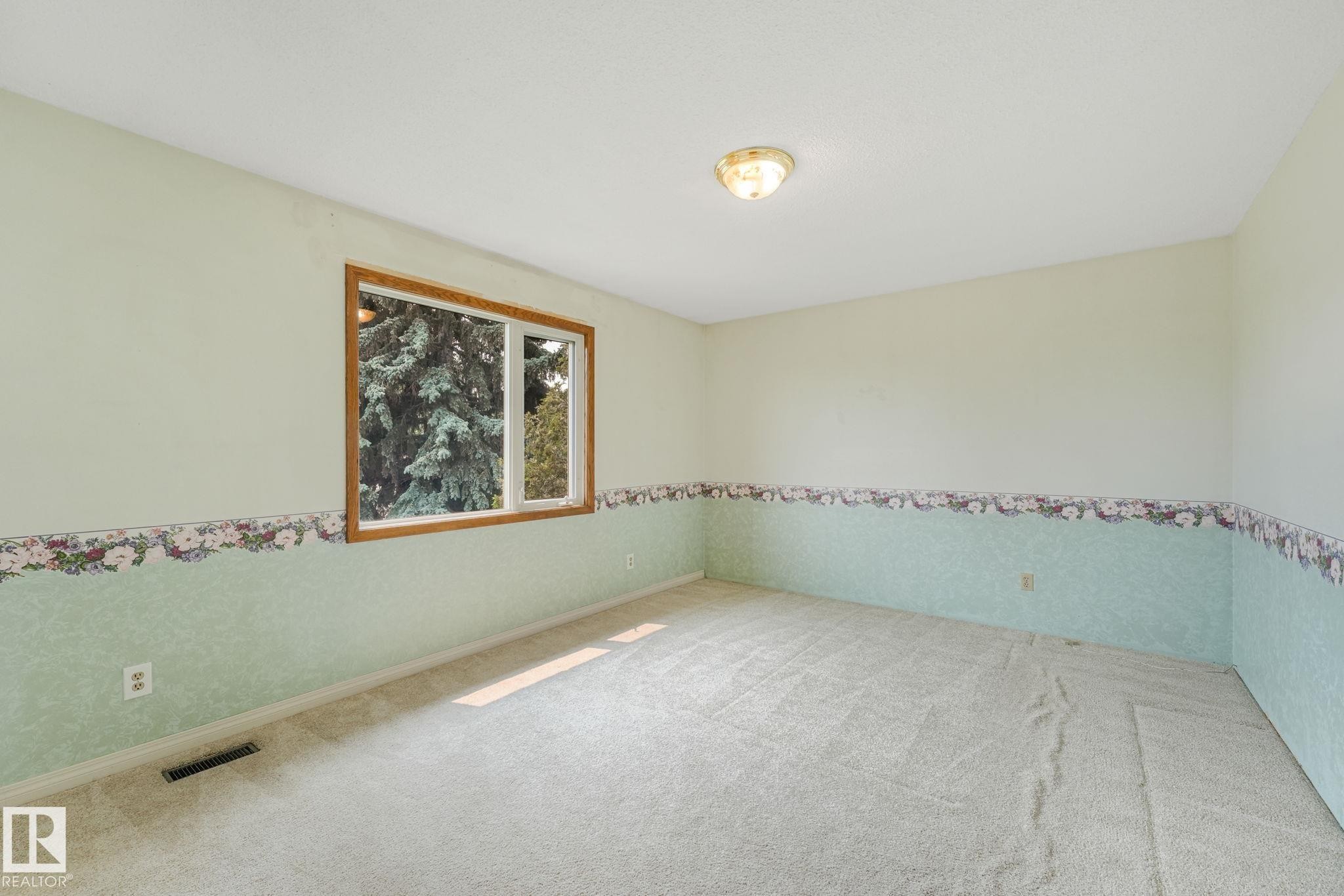 Carpeted room with a wooden-framed window and a flush-mount ceiling light fixture - 13320 79 Avenue Nw, Edmonton, AB - Indoor Photo Showing Other Room