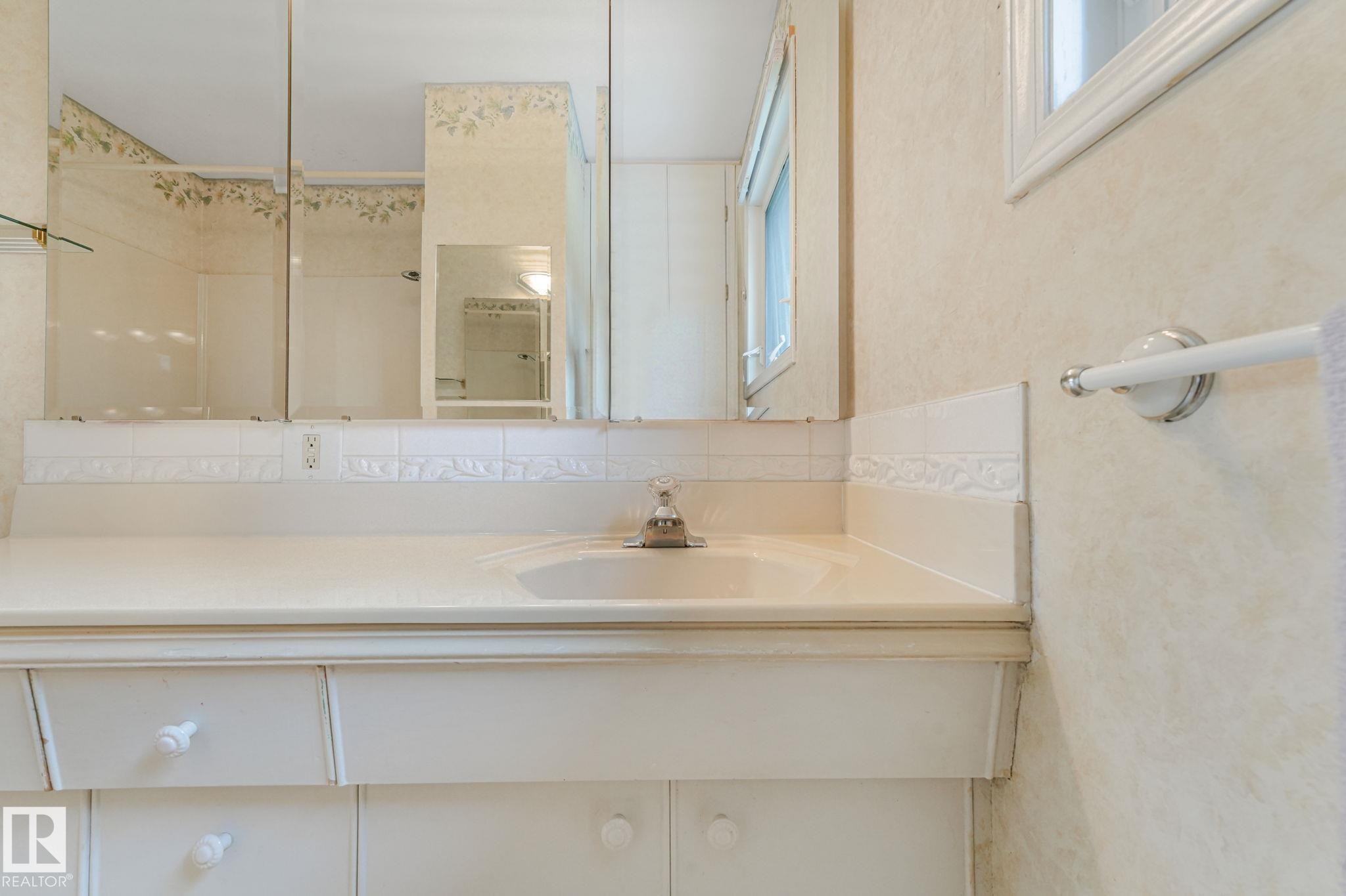 Bathroom vanity featuring an integrated sink with a chrome faucet - 13320 79 Avenue Nw, Edmonton, AB - Indoor Photo Showing Bathroom