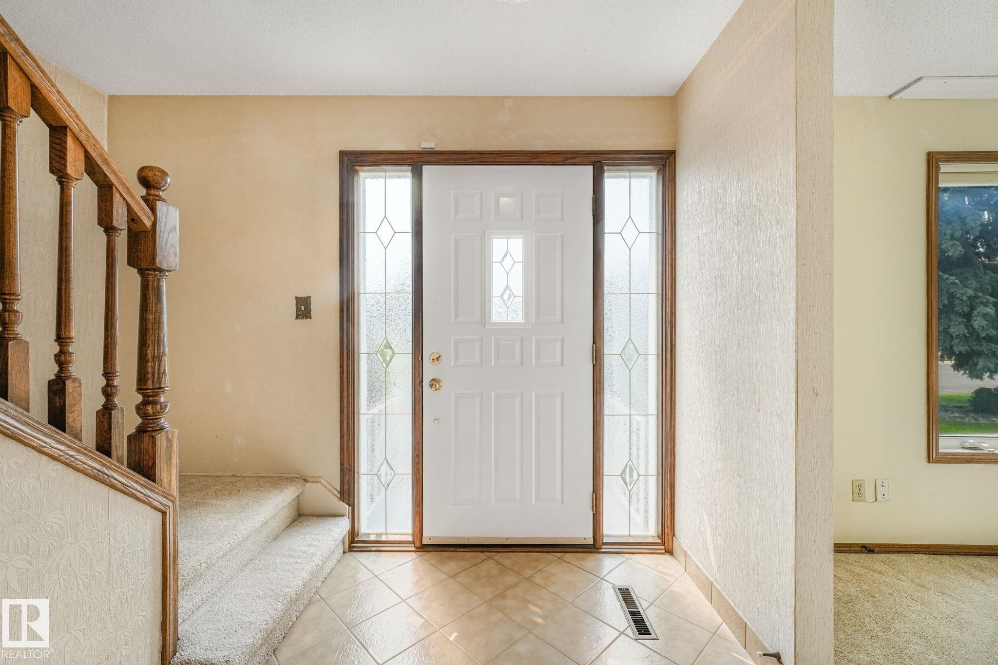 Entryway featuring a white paneled door with decorative glass inserts, flanked by matching sidelight windows - 13320 79 Avenue Nw, Edmonton, AB - Indoor Photo Showing Other Room