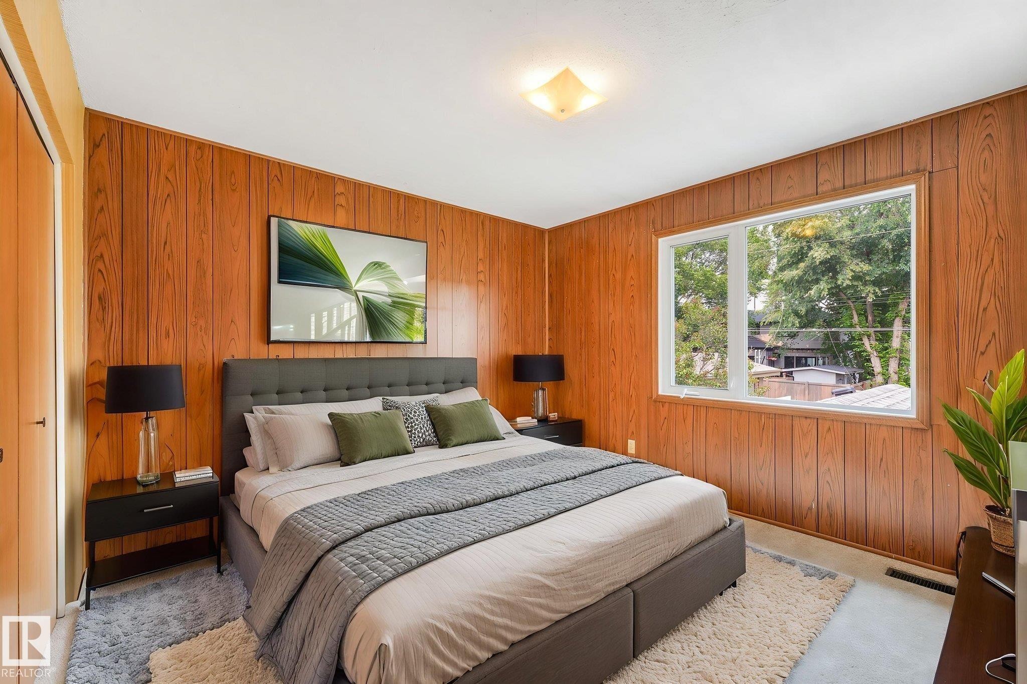 Room featuring wood-paneled walls and a large picture window - 13320 79 Avenue Nw, Edmonton, AB - Indoor Photo Showing Bedroom