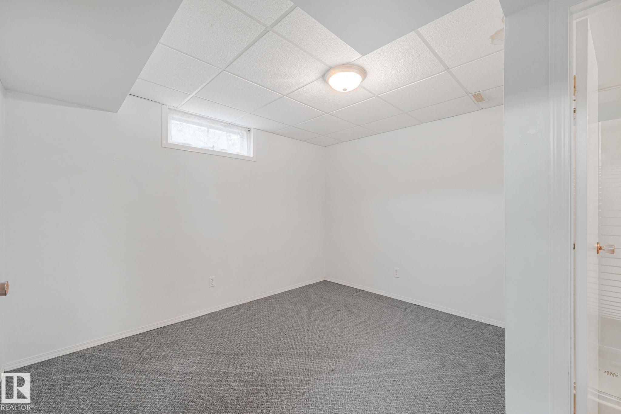 Neutral white walls and grey carpeting create a versatile foundation - 13320 79 Avenue Nw, Edmonton, AB - Indoor Photo Showing Other Room