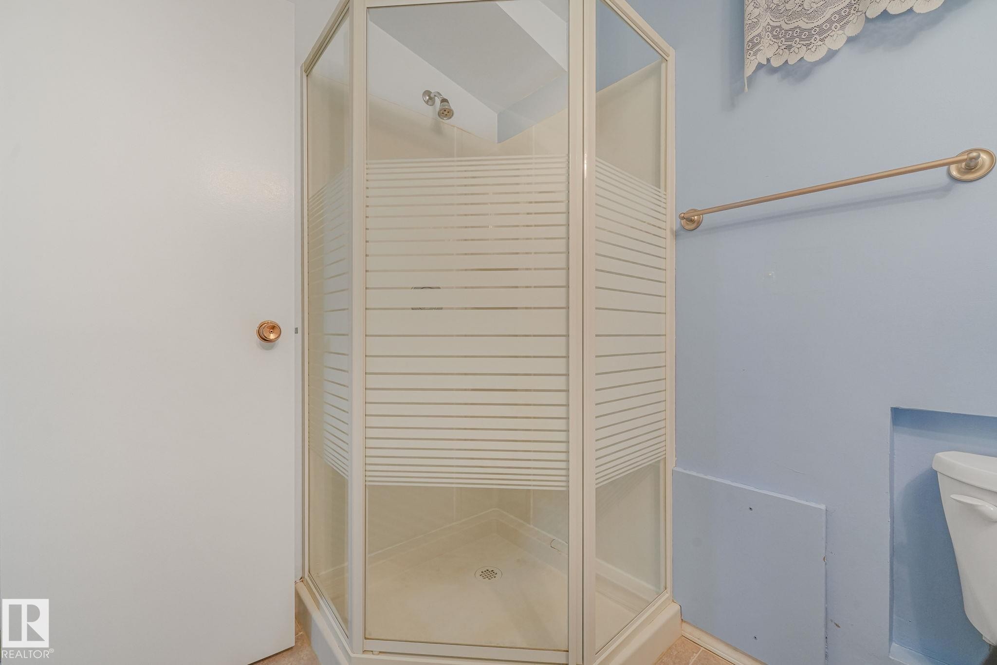 Corner shower enclosure with frosted glass panels and a white frame - 13320 79 Avenue Nw, Edmonton, AB - Indoor Photo Showing Bathroom