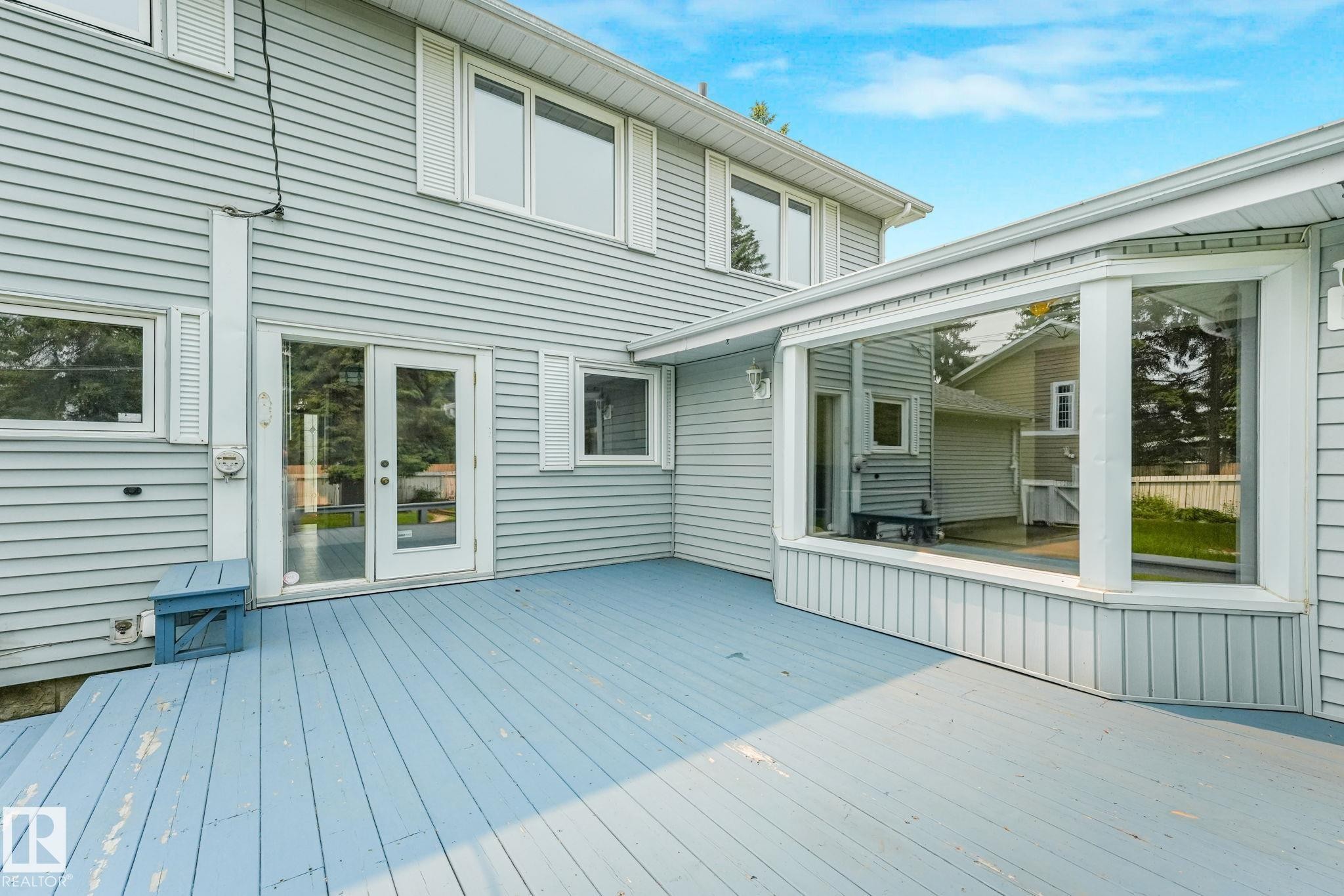 Expansive deck with light blue wood-finish flooring, a large bay window feature, and glass-paned double doors - 13320 79 Avenue Nw, Edmonton, AB - Outdoor With Deck Patio Veranda With Exterior