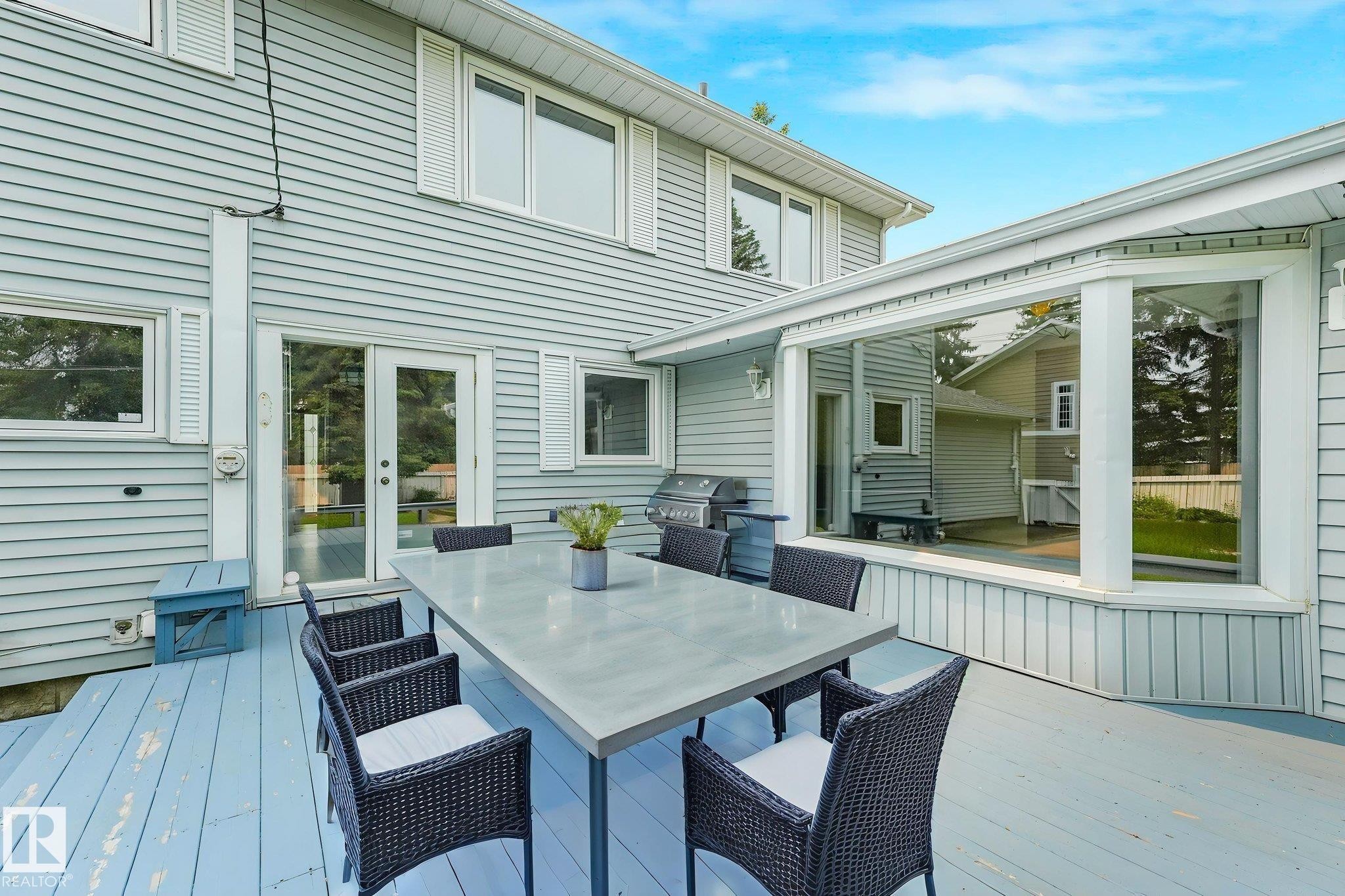 Exterior deck featuring a bay window, glass patio doors, and light blue siding - 13320 79 Avenue Nw, Edmonton, AB - Outdoor With Deck Patio Veranda With Exterior