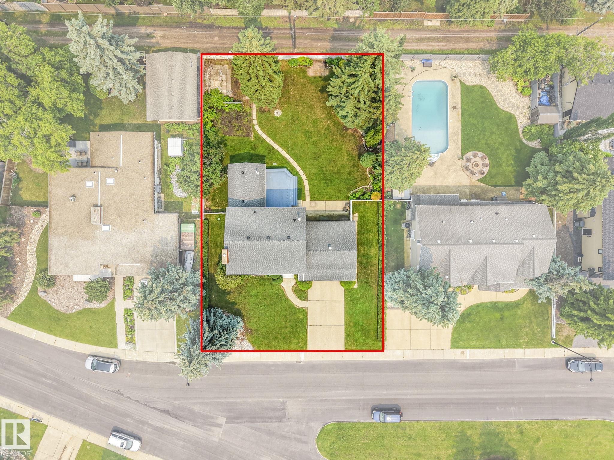 Aerial overview showcasing a substantial property with extensive green space, a paved driveway, and mature landscaping - 13320 79 Avenue Nw, Edmonton, AB -