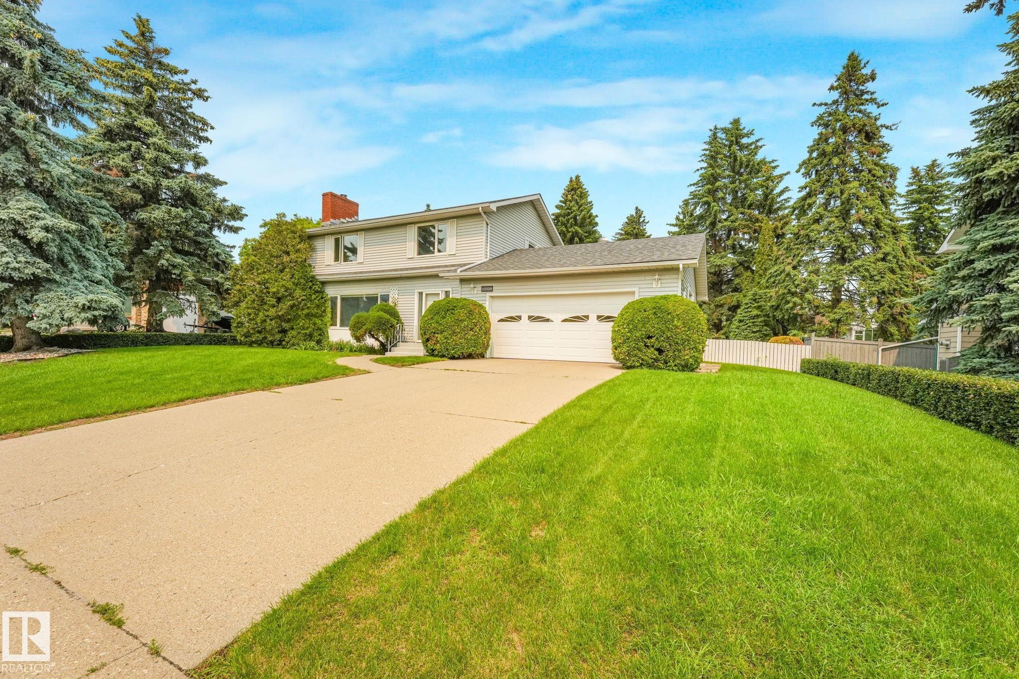 Two-story residence featuring light-colored siding, an attached garage, and a concrete driveway - 13320 79 Avenue Nw, Edmonton, AB - Outdoor
