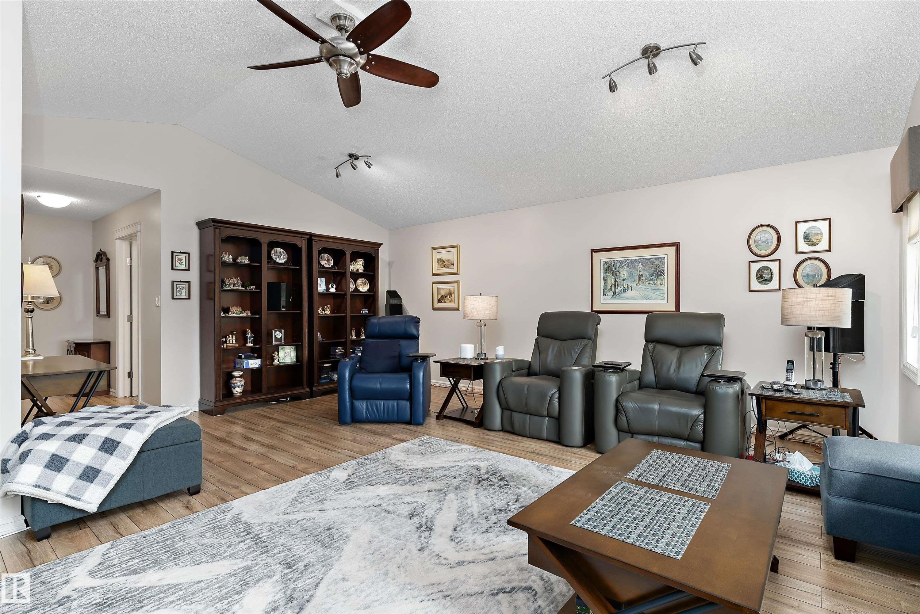 Spacious living area featuring vaulted ceilings, wood-finish flooring, and built-in display cabinetry - 1097 Armitage Crescent, Edmonton, AB