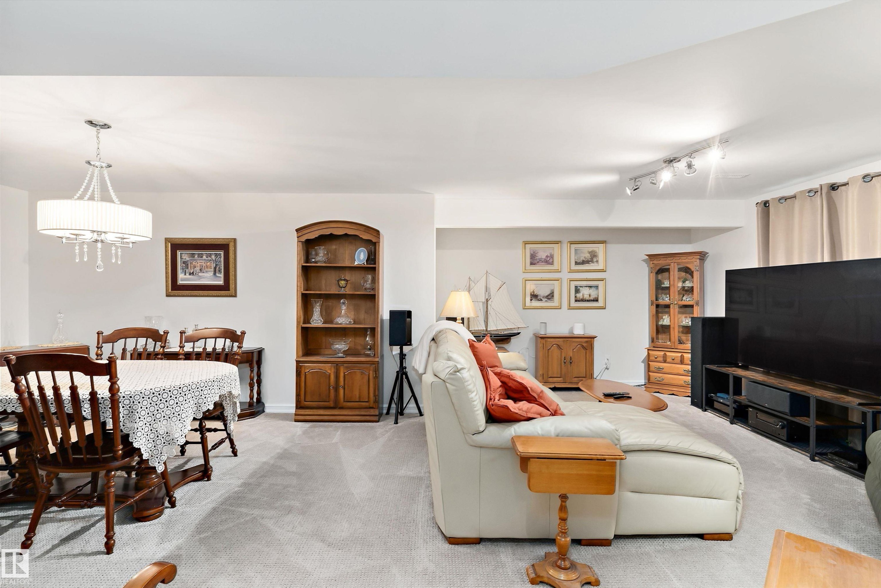 Open-concept living area with light gray carpeting and white walls - 1097 Armitage Crescent, Edmonton, AB