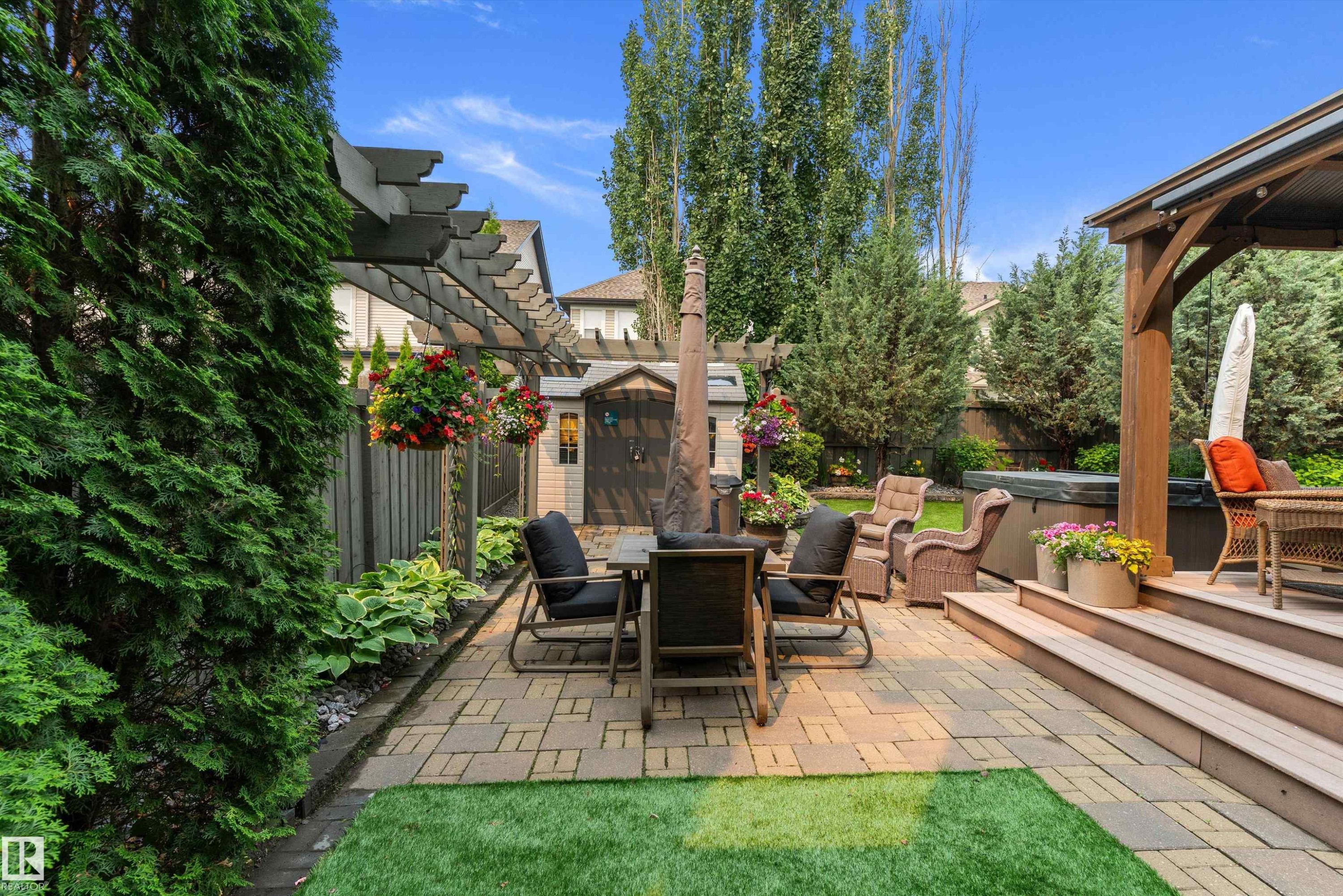 Expansive outdoor living area featuring a paver patio, composite deck with covered pergola, and a garden shed for storage - 1097 Armitage Crescent, Edmonton, AB