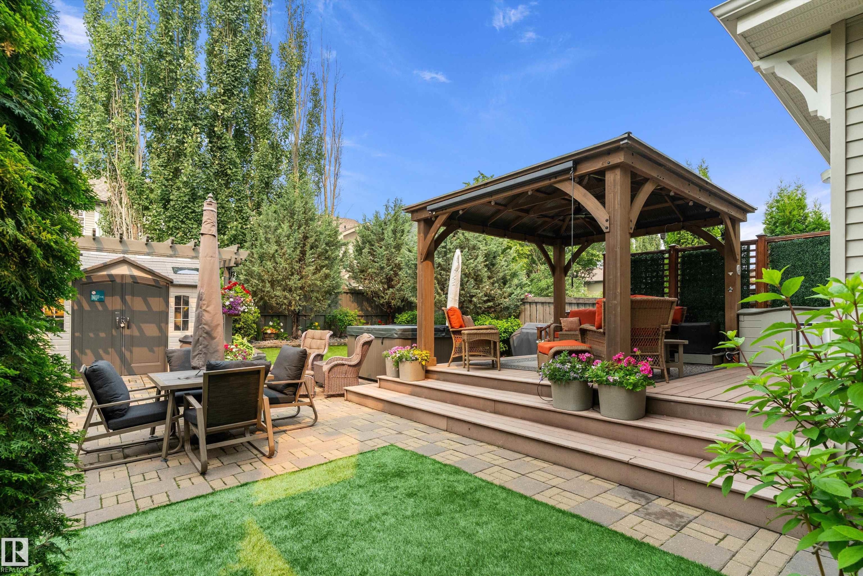 Expansive backyard featuring a multi-level deck, a wooden gazebo, and a paved patio area - 1097 Armitage Crescent, Edmonton, AB