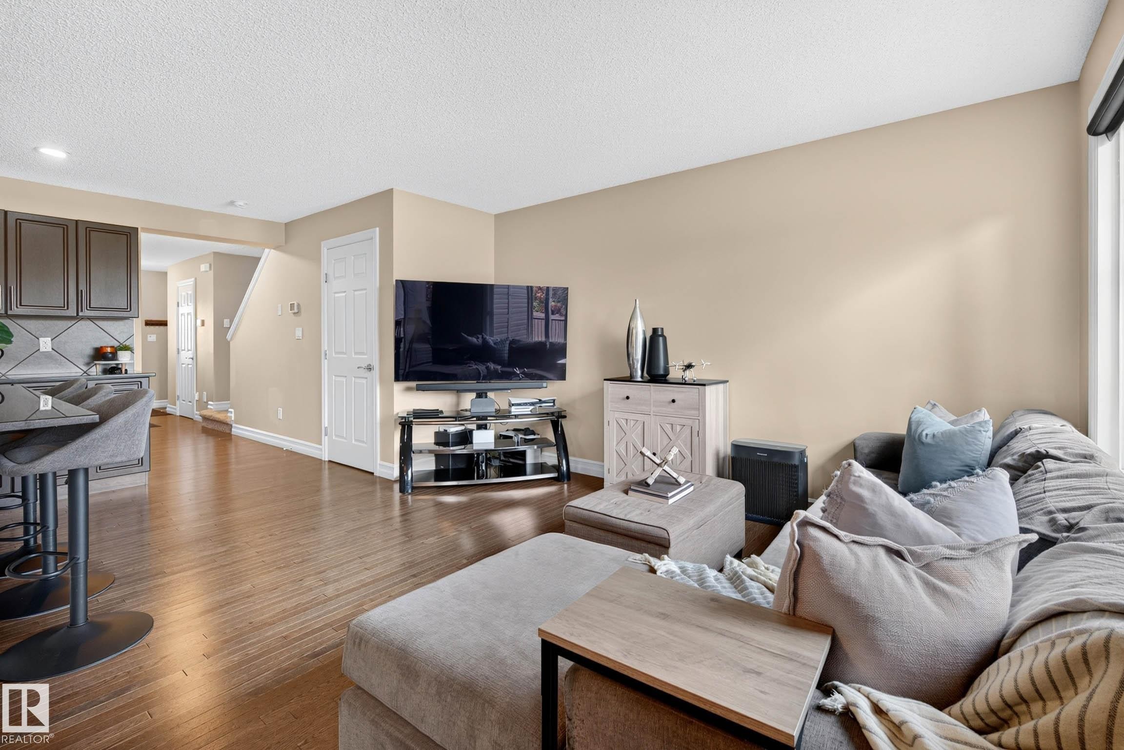 Open-concept living space with wood-finish flooring, a neutral wall palette, and recessed ceiling lighting - 12119 167A Avenue, Edmonton, AB