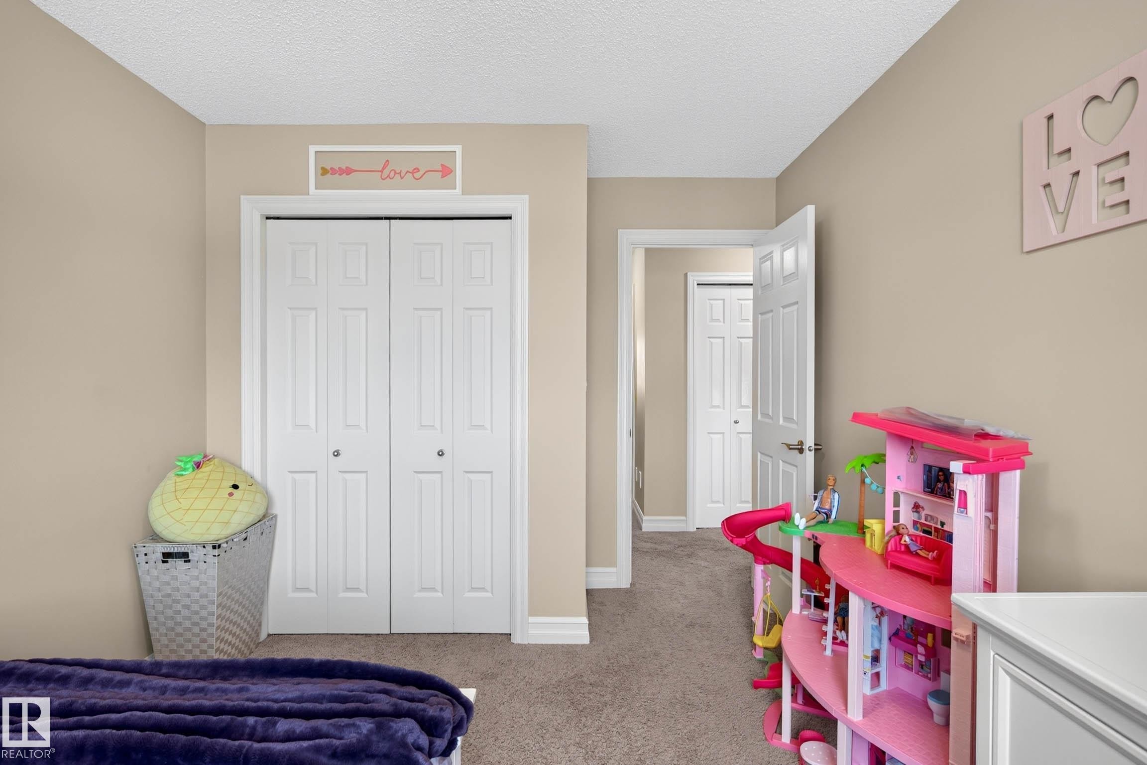 Neutral-toned walls complement the textured ceiling, with a white bi-fold closet door offering storage - 12119 167A Avenue, Edmonton, AB